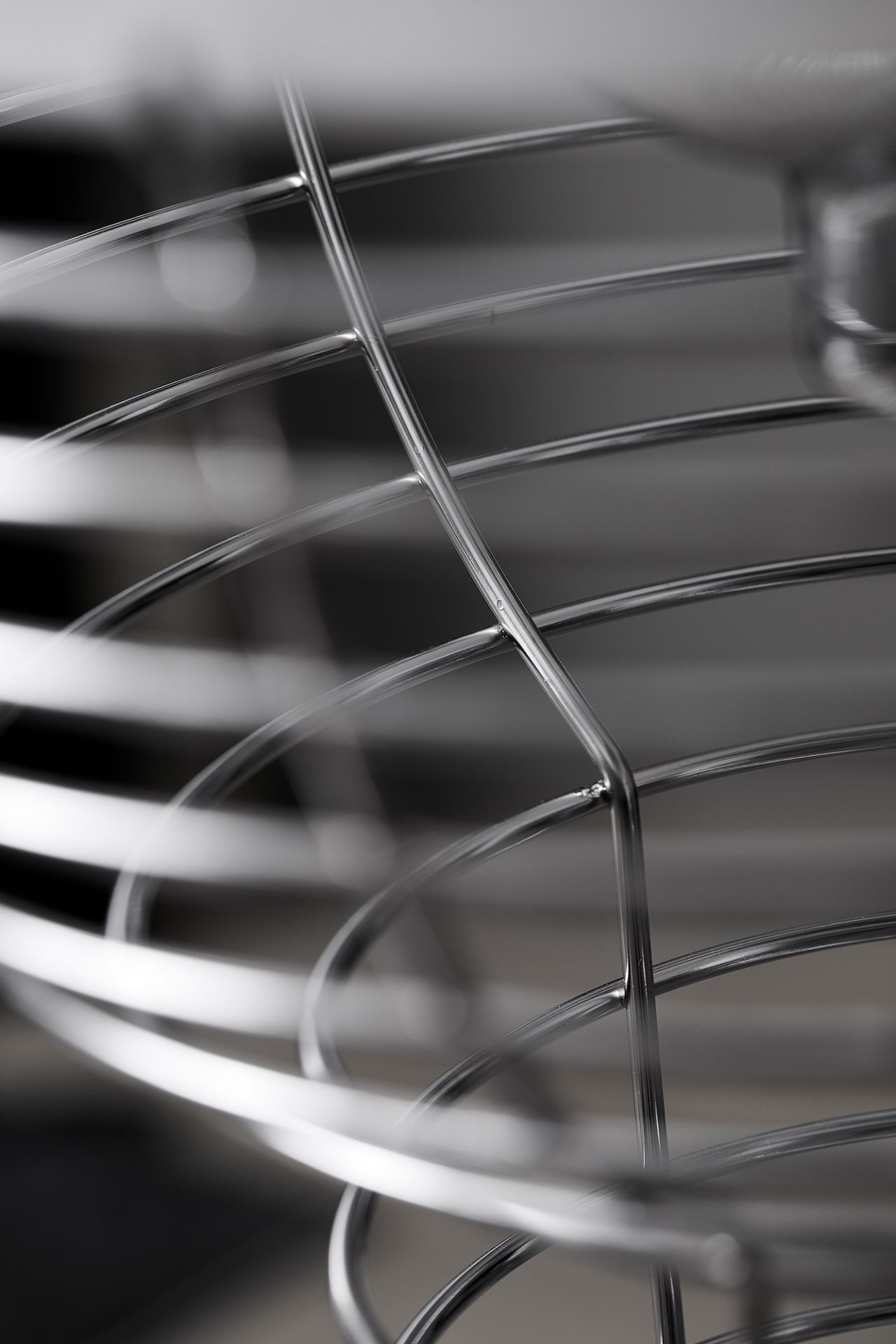 Detailaufnahme der Verpan Wire Stehleuchte: Filigrane, verchromte Metallstruktur mit verschwommenem Hintergrund für moderne Raumbeleuchtung.