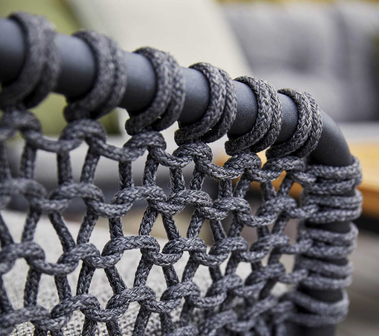Detailaufnahme: Cane-Line Ocean Loungesessel, graues Seilgeflecht um schwarzes Gestell, Outdoor Möbel.