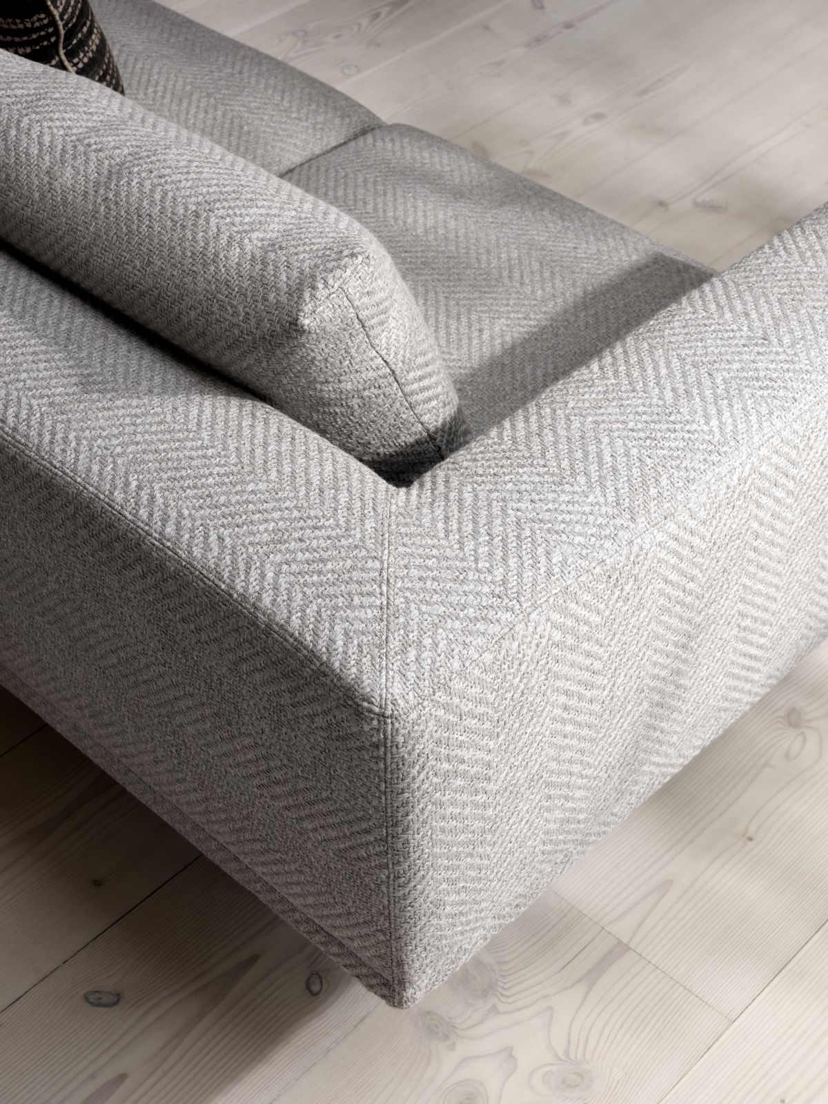 Detailaufnahme des Vipp Loft Modulsofas, ein graues 3-Sitzer Sofa mit Fischgrätenmuster.