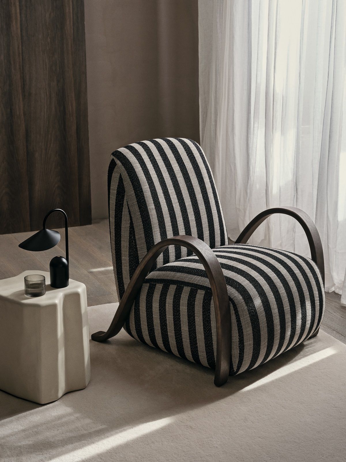 Buur Lounge Chair von Ferm Living mit schwarz-weiß gestreiftem Stoff und Holzarmlehnen.