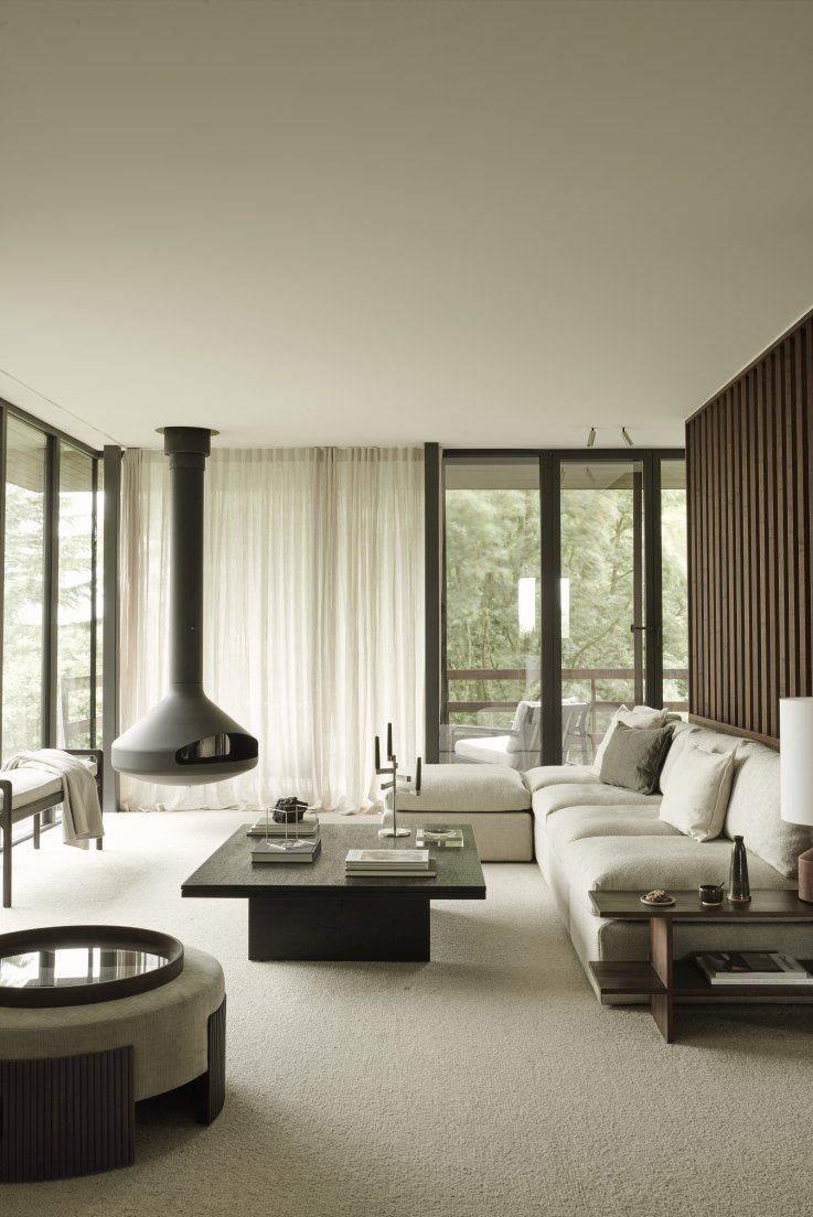 Wohnzimmer mit Ethnicraft Couchtisch "Grooves", schwarzem Holztisch und modernem Interieur.