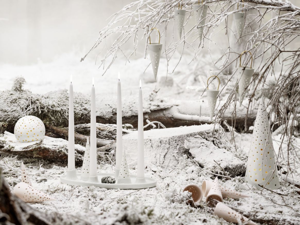 Nobili Teelichthalter Schneeweiß von Kähler im winterlichen Arrangement mit Kerzen, Teelichtern und Dekoration im Schnee.