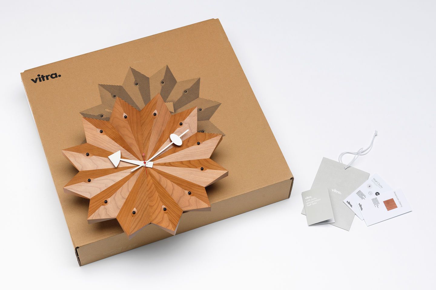 Vitra Fan Clock Wanduhr aus Kirschbaumholz mit weißem Zeiger auf Kartonverpackung. Design Wanduhr.