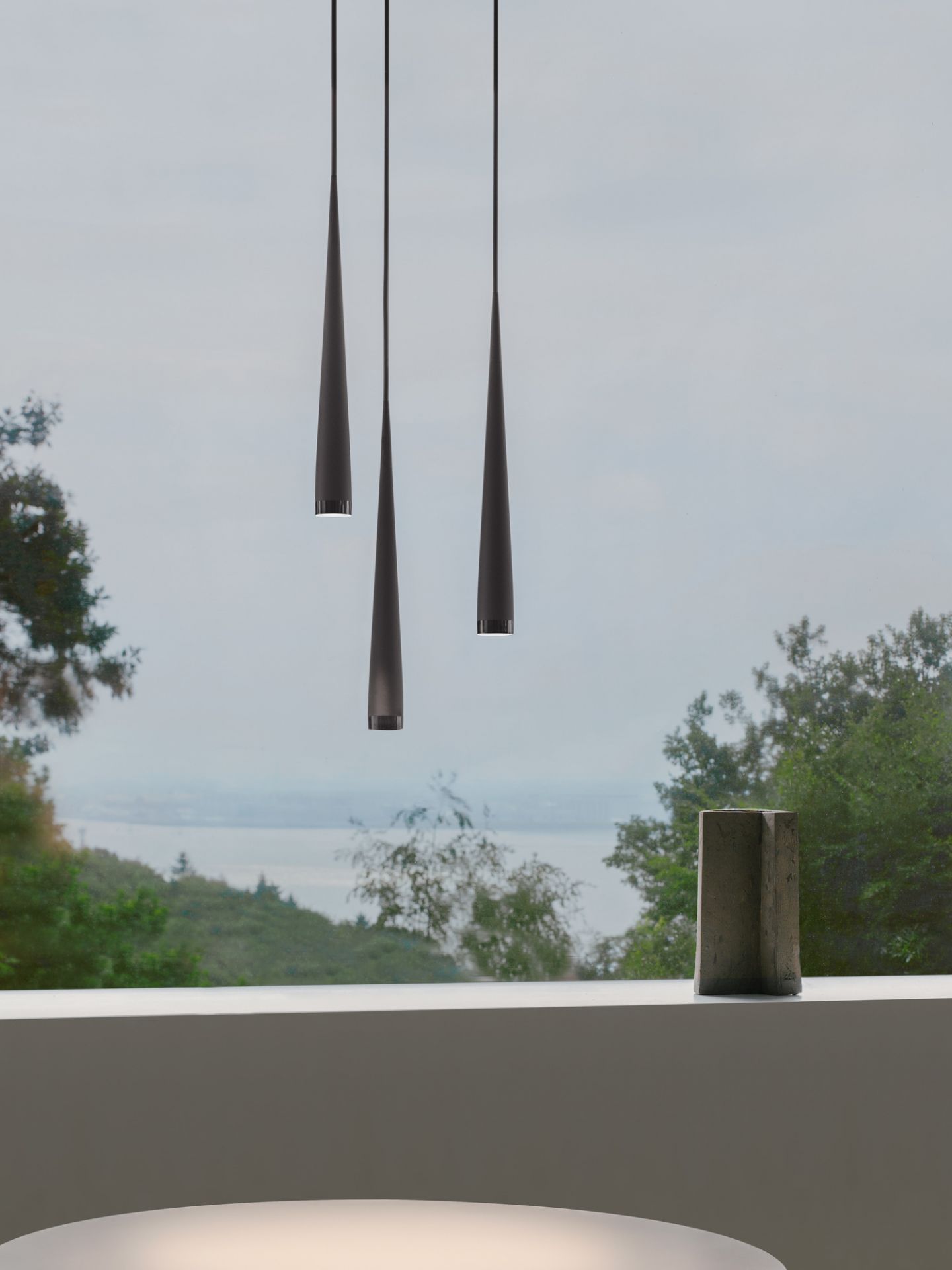 Drei graue Pendelleuchten im Kegeldesign. Moderne Hängelampe für Esszimmer oder Wohnzimmer. Niceone Leuchte.