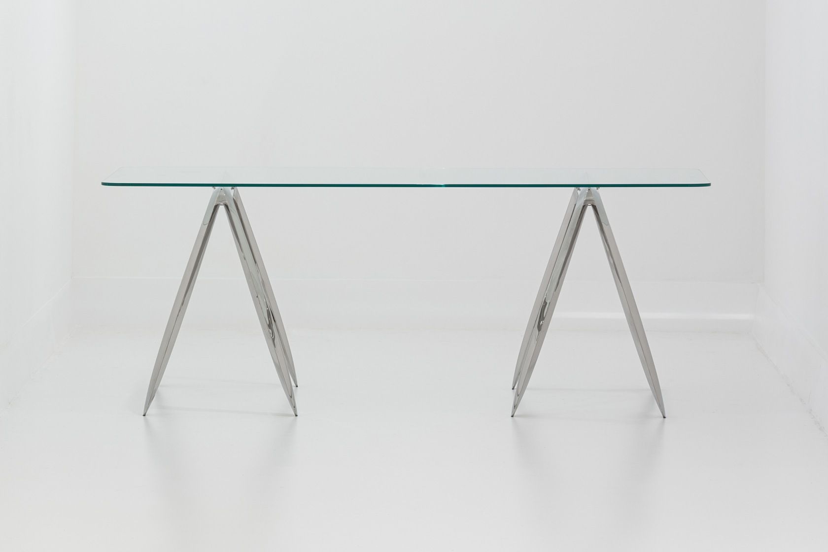 Koza Tischgestell von Zieta mit Glasplatte und silberfarbenen, dreieckigen Metallbeinen auf weißem Hintergrund.