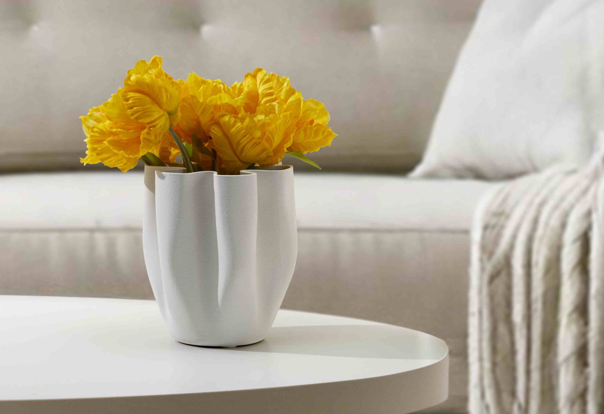 Weiße Philippi Livree Vase mit gelben Tulpen auf einem runden Tisch, moderne Blumenvase.