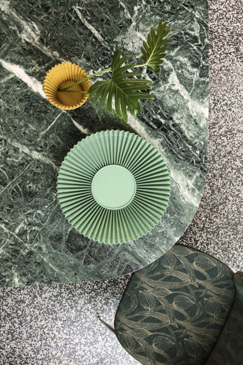 Draufsicht: Grüner Matégot Blumentopf von Gubi auf Marmortisch mit gelbem Übertopf und Pflanze.