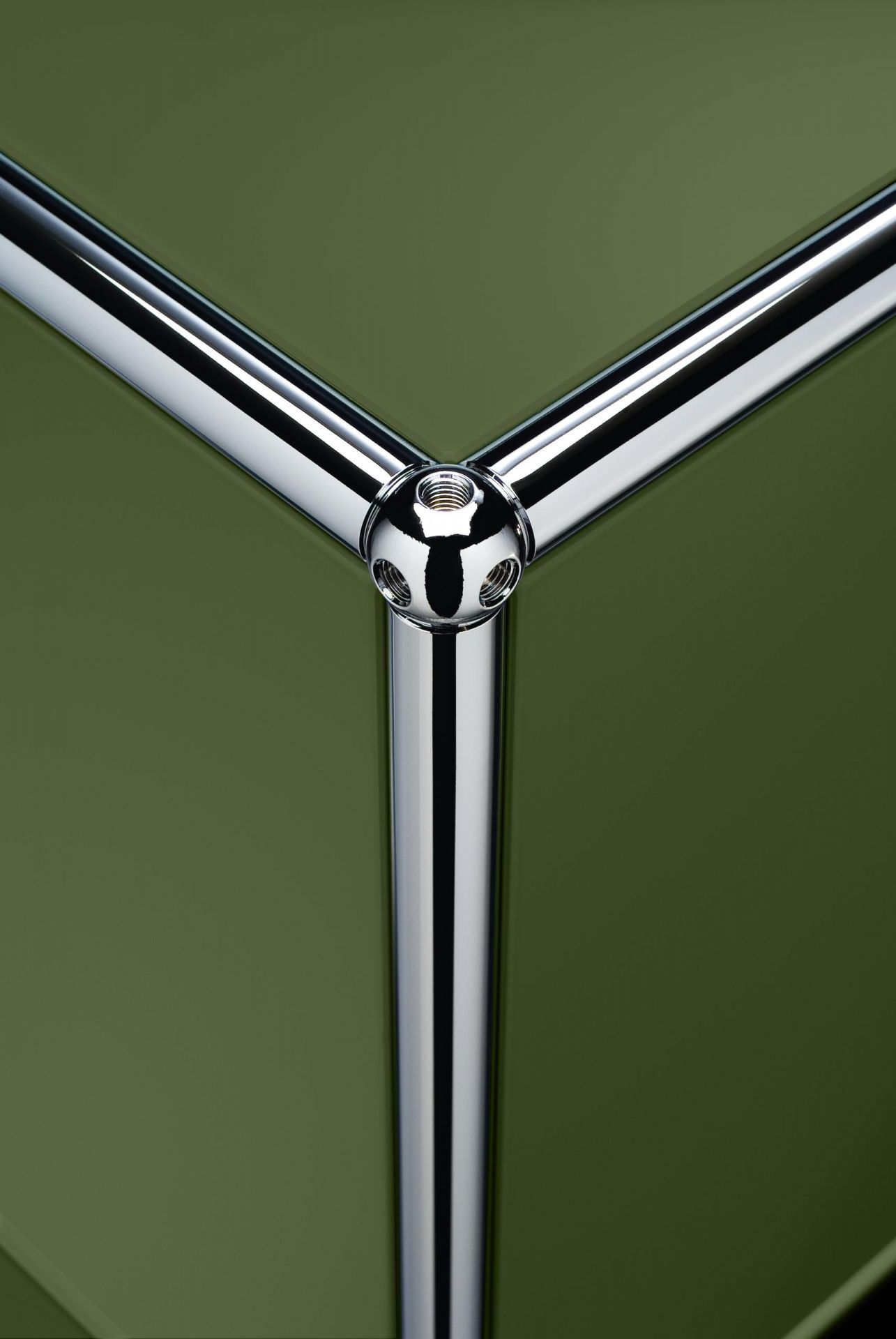 Detailaufnahme USM Haller Sideboard in Olivgrün: Verbindungselement und Chromrohre des modularen Möbelstücks.