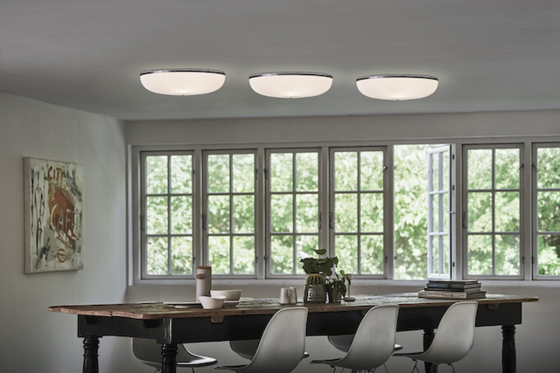 Drei Lamella Deckenleuchten von Le Klint im Esszimmer, moderne Innenbeleuchtung mit goldenem Akzent.