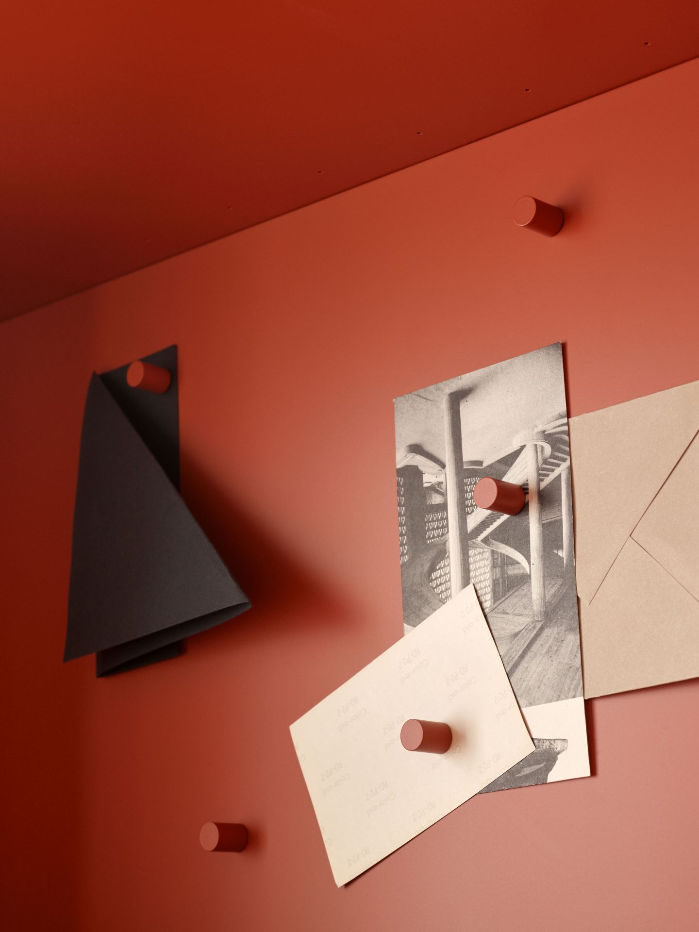 Detailaufnahme des STUDIO Sekretärs in Terrakotta mit Notizen und Umschlag an Magneten.