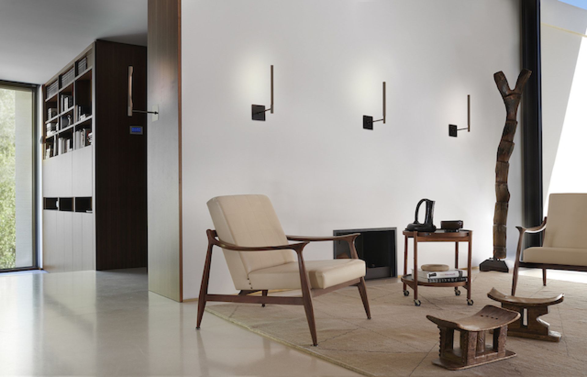 Wohnraum mit drei Ilo Wandleuchten in Satin Bronze von Oluce an der Wand.