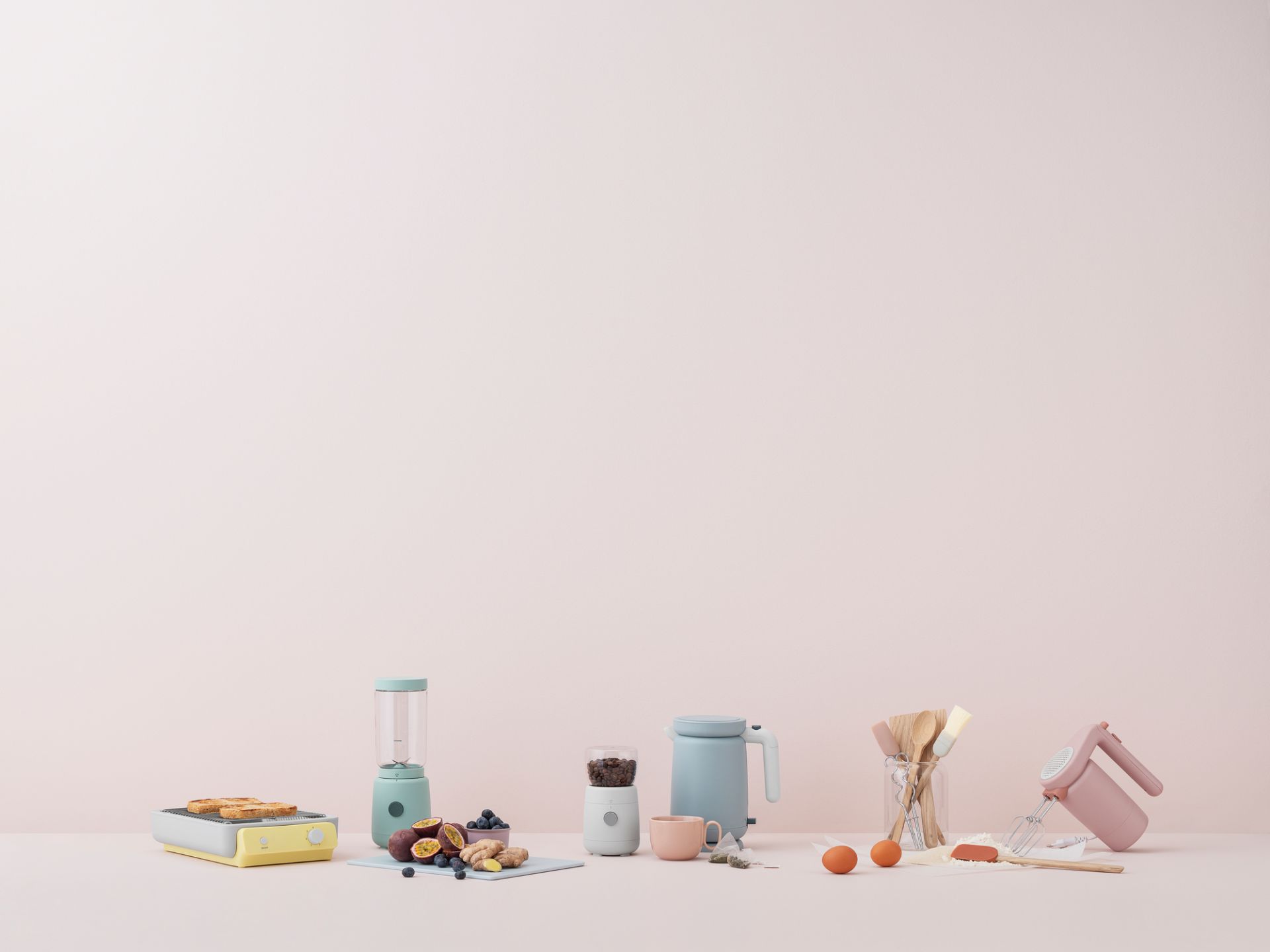 Hellrosa Foodie Handmixer von RIG-TIG by Stelton neben anderen Küchengeräten und Zutaten.