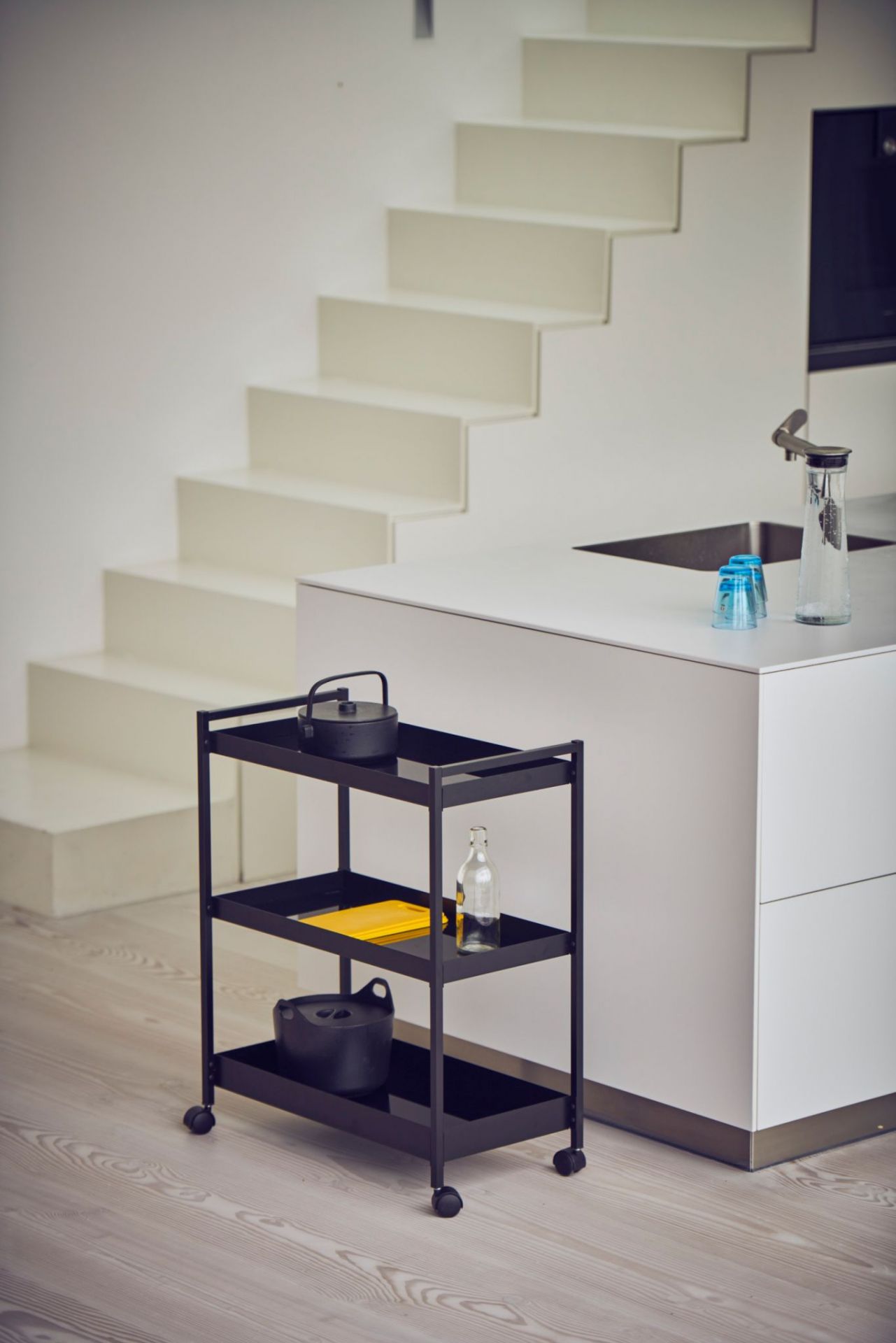 Schwarzer Jan Kurtz Servierwagen "Butler L" mit drei Ablagen und Rollen in moderner Küche.
