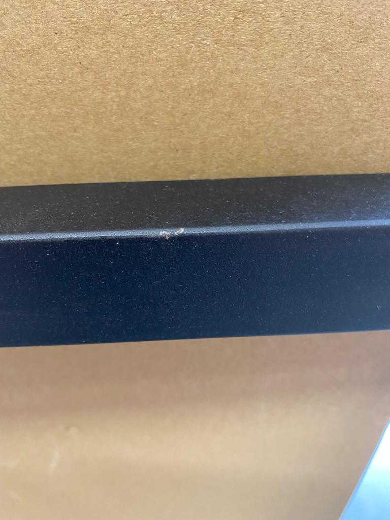 Detailaufnahme: Beschädigung am schwarzen Metallgestell des Kant Esstisches von House Doctor. Mängelexemplar.