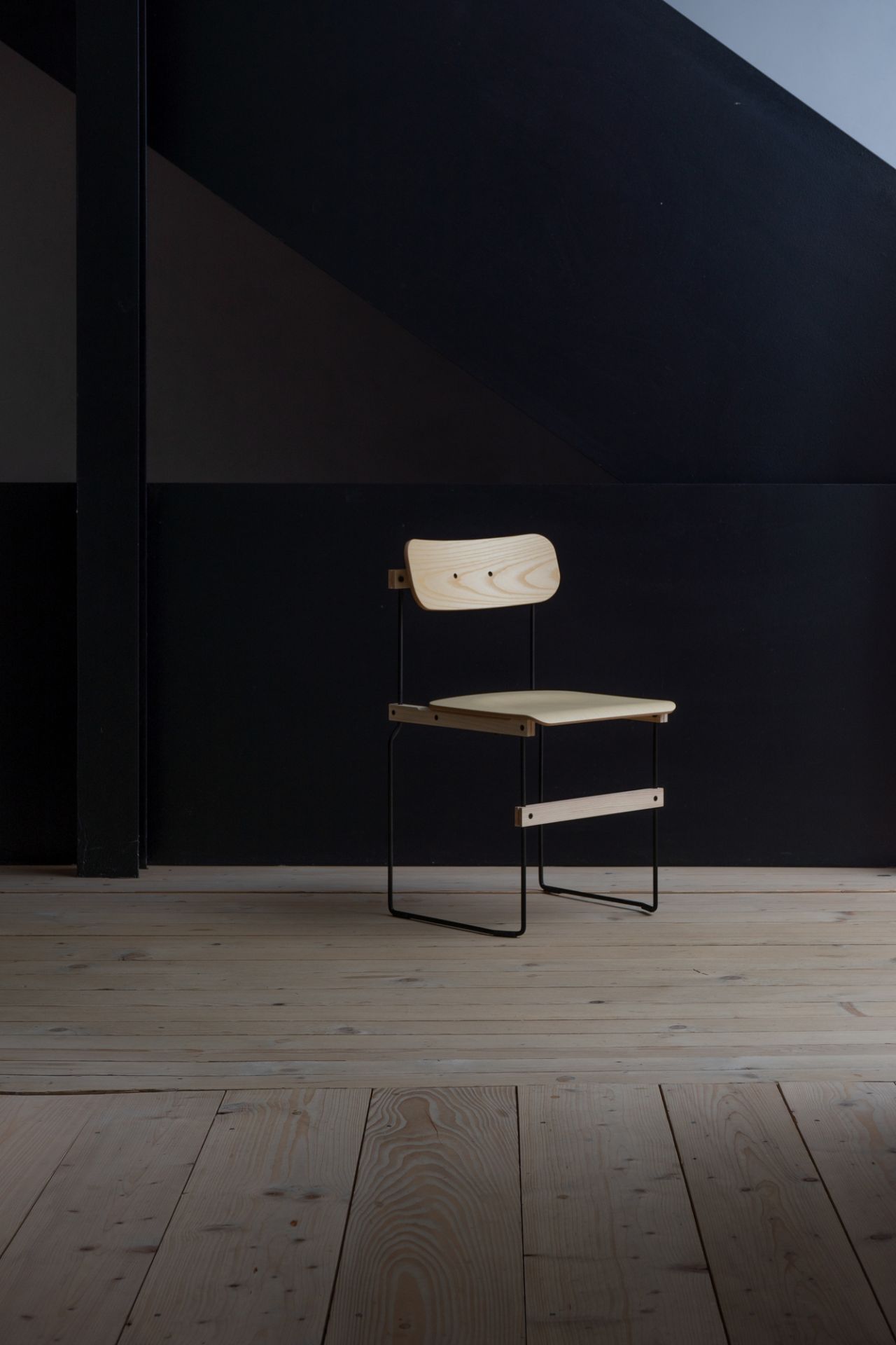 Bruto Stuhl von Nils Holger Moormann: Holzstuhl mit schwarzem Metallgestell auf hellem Holzboden.