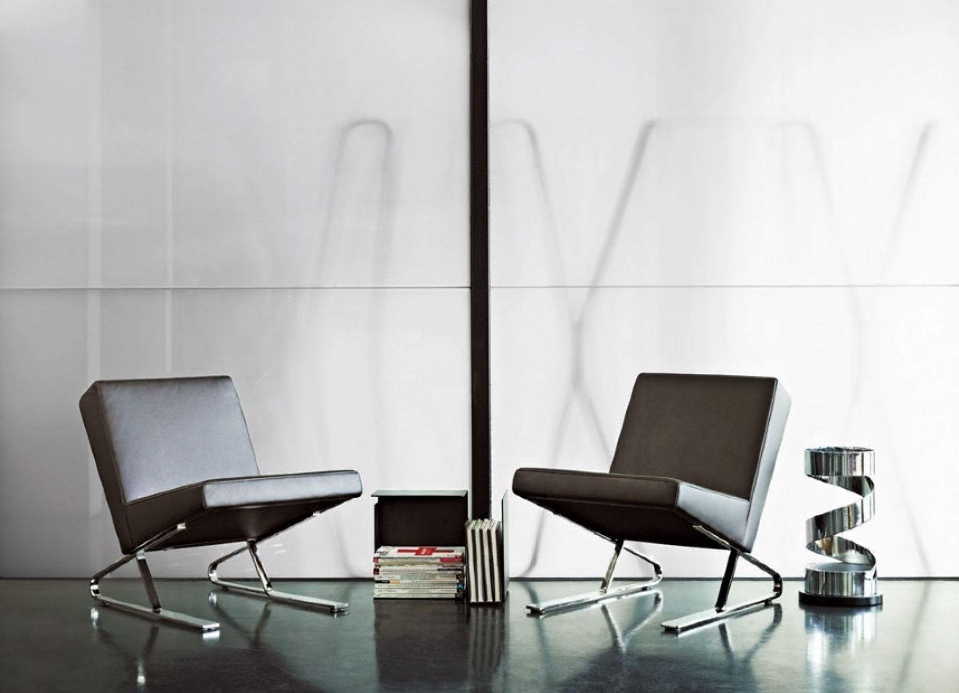 Zwei ClassiCon Sessel mit Chromgestell und ein Usha Schirmständer aus Chrom in modernem Ambiente.