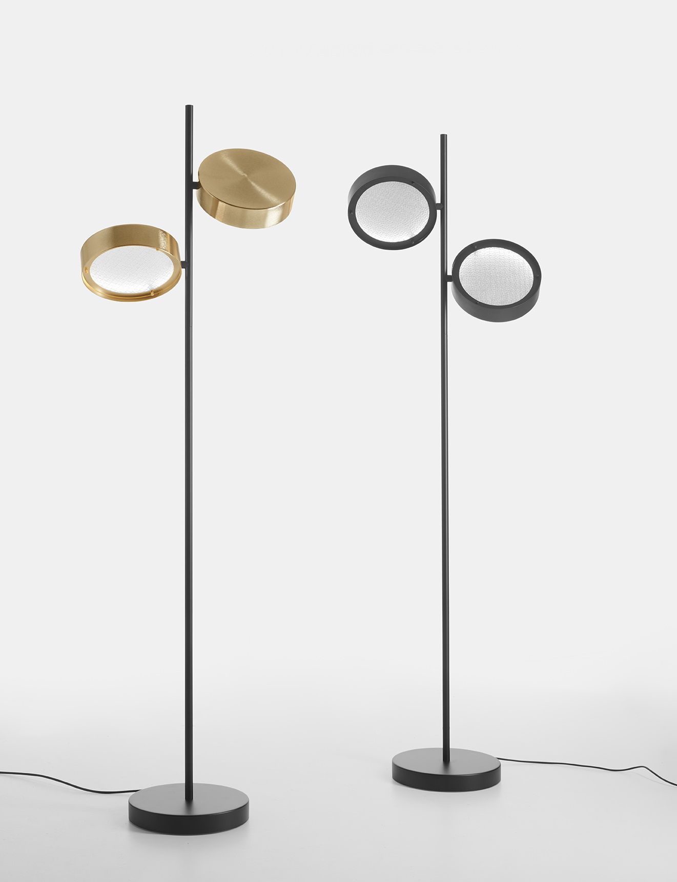 Zwei Oluce Berlin Stehleuchten: Goldene und schwarze Ausführung mit runden Lampenschirmen.