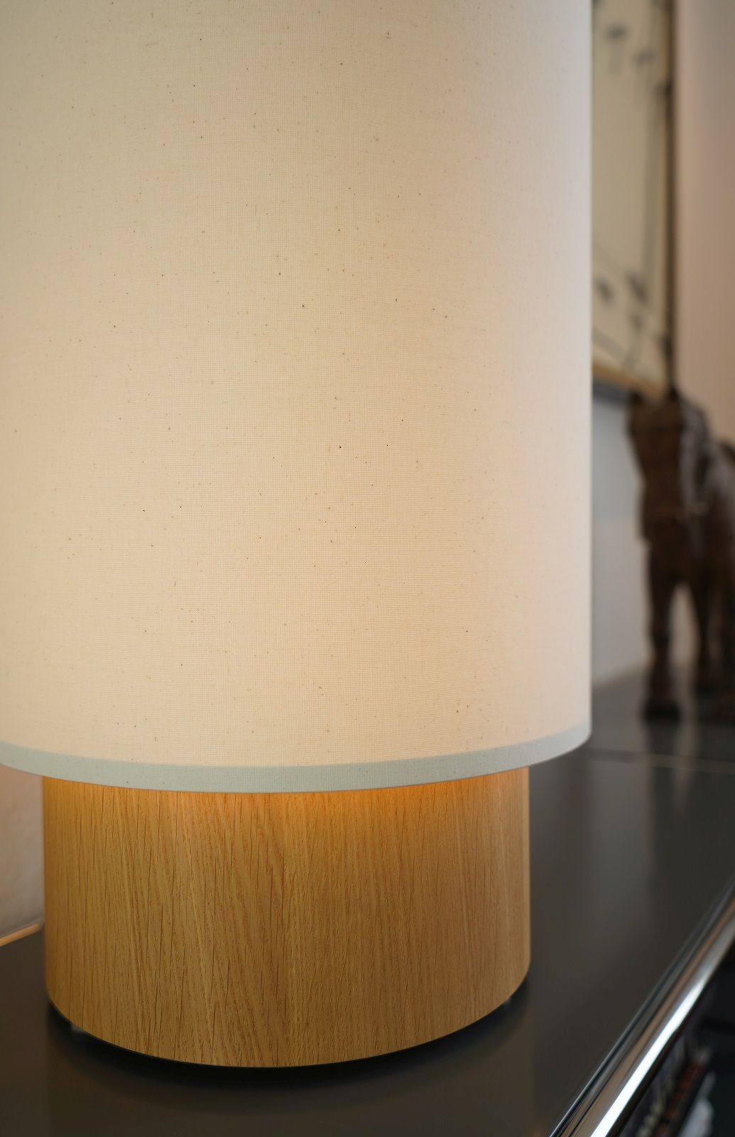 Detailaufnahme: Maigrau Hiro Tischleuchte mit hellem Schirm und Holzfuß. Moderne Lampe.