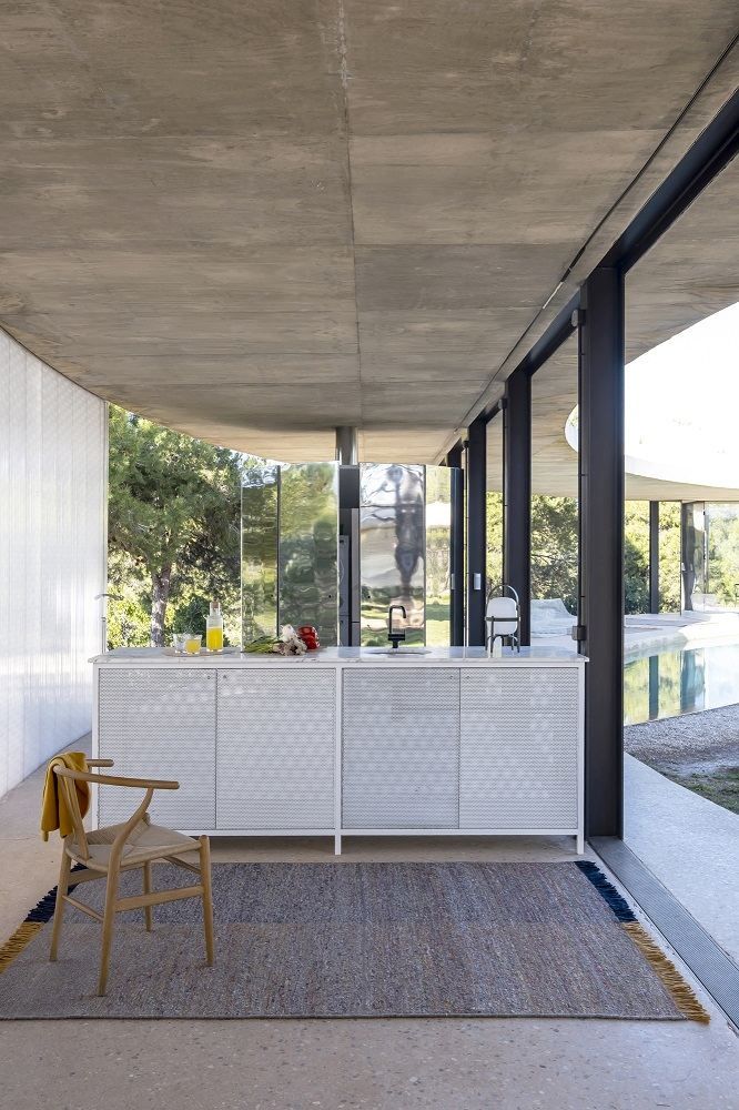 Grauer Re-Rug Teppich von Nanimarquina (ca. 200x300 cm) in modernem Wohnraum mit Stuhl.