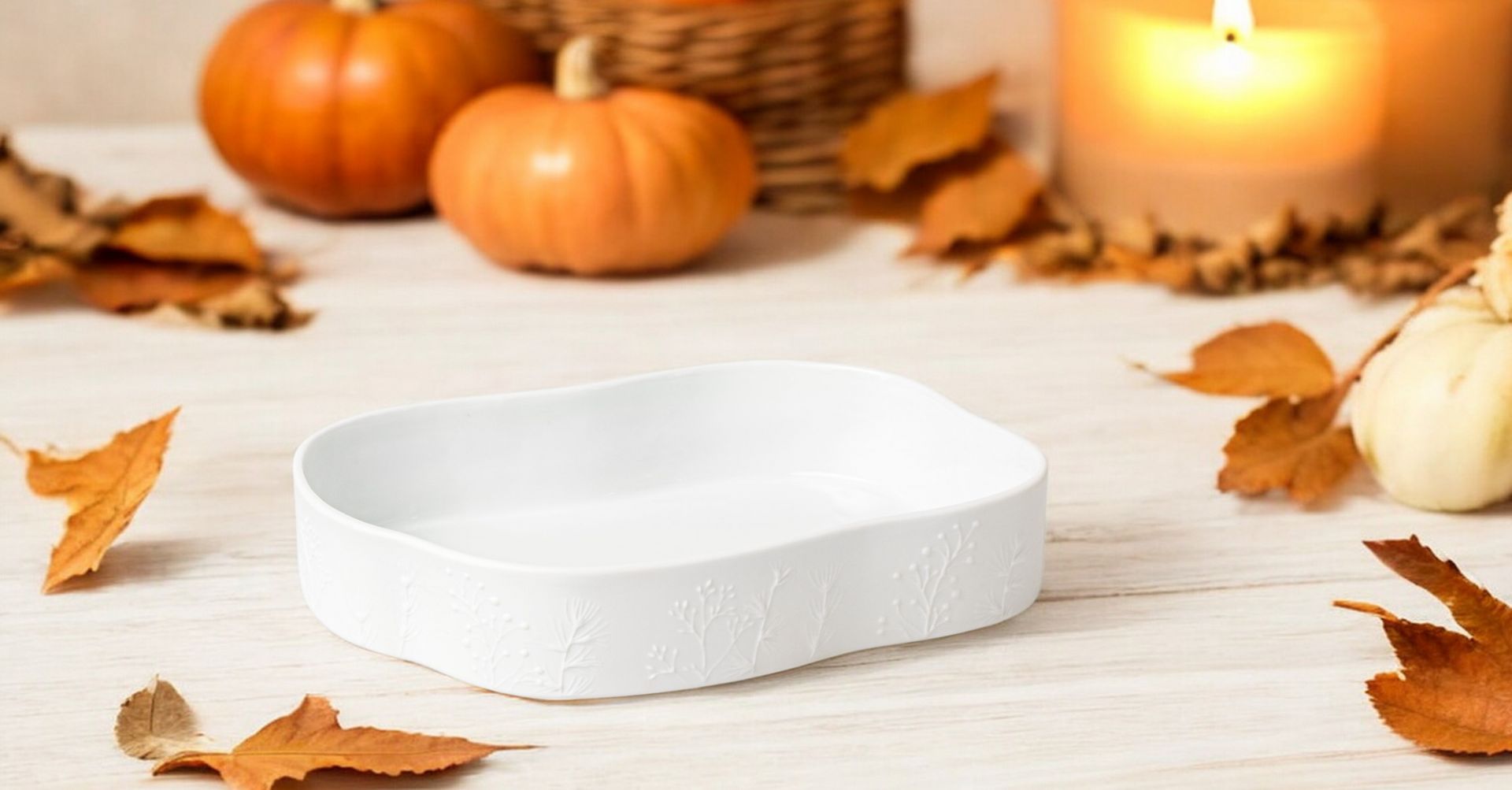 Weiße Räder Schale "Winterzauber" mit Herbstdeko, Kürbissen, Kerzen und Blättern für stimmungsvolle Tischdekoration.