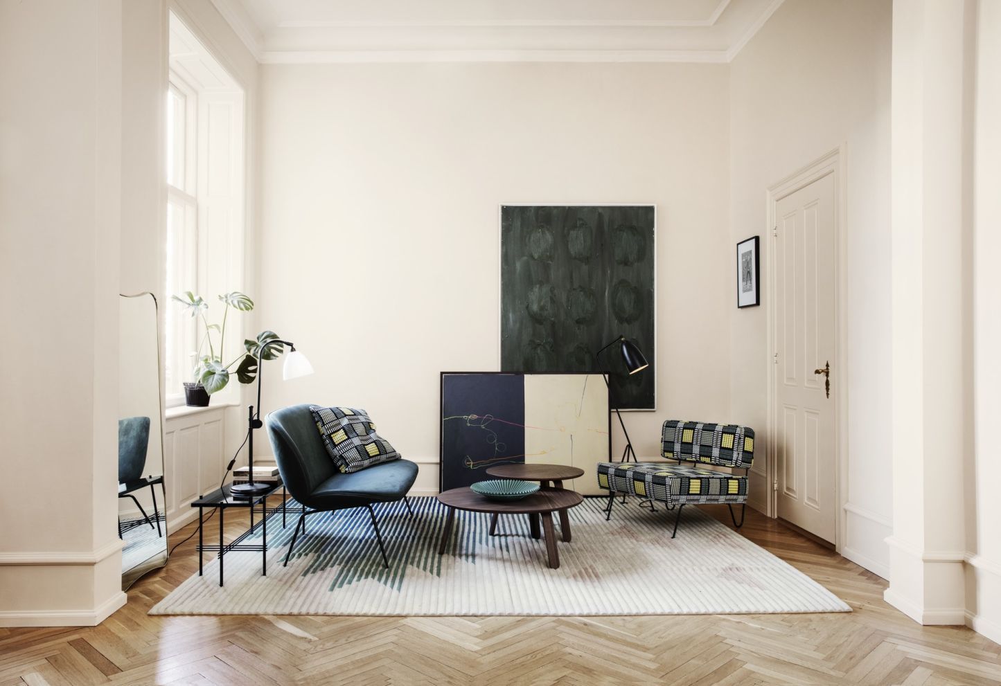 Wohnzimmer mit Designermöbeln und F.A. 33 Wandspiegel von Gubi, der sich dezent im Raum spiegelt.