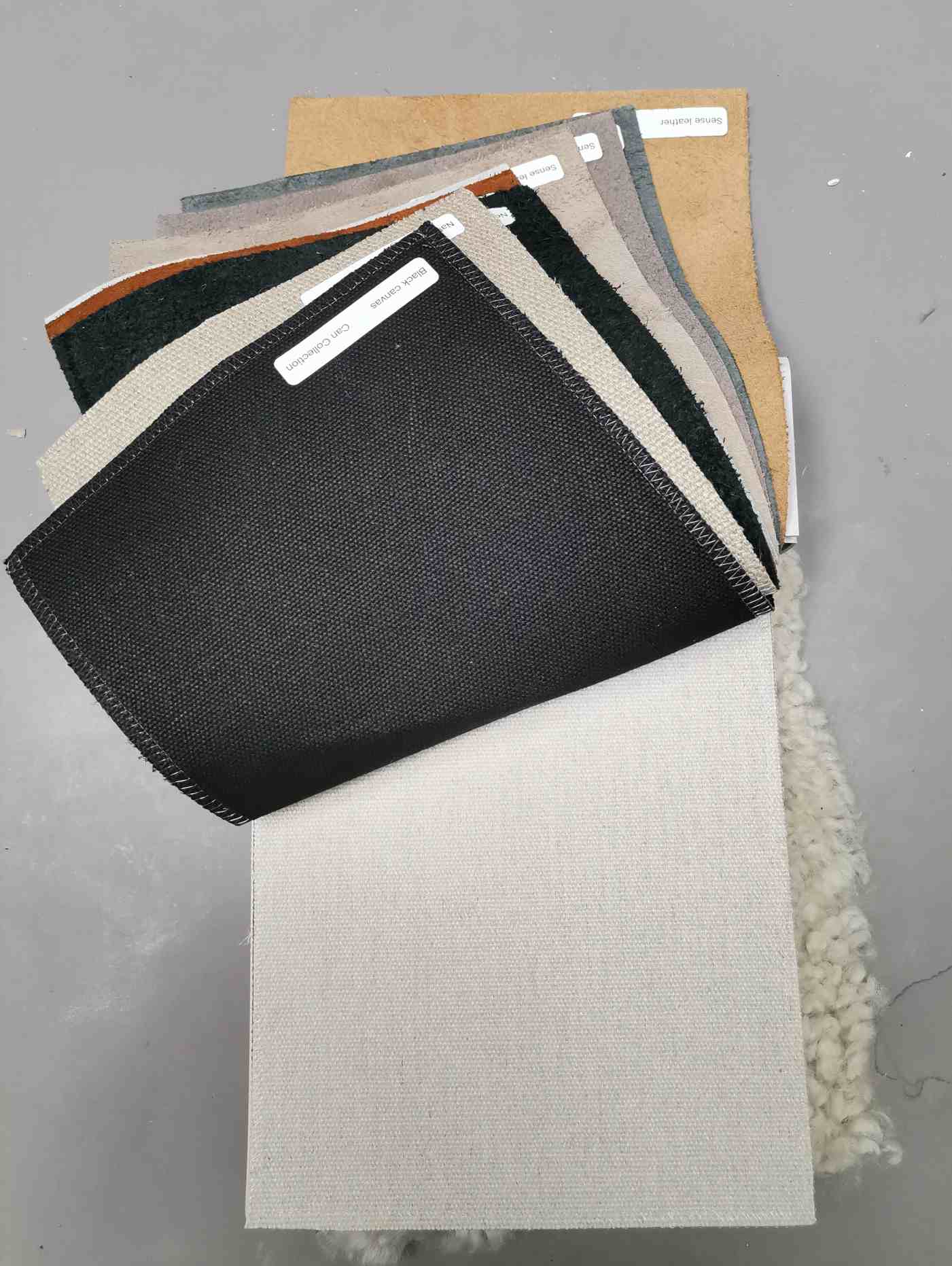 Musterkollektion Leder und Canvas Hay: Verschiedene Stoff- und Ledermuster in unterschiedlichen Farben und Texturen.