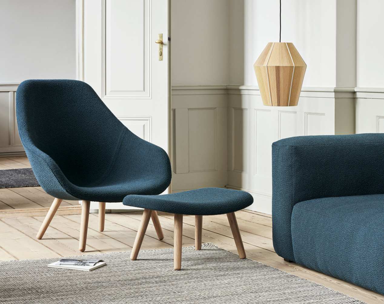 Blauer About A Lounge Sessel mit passendem Hocker von Hay, modernes Möbeldesign für Wohnzimmer.