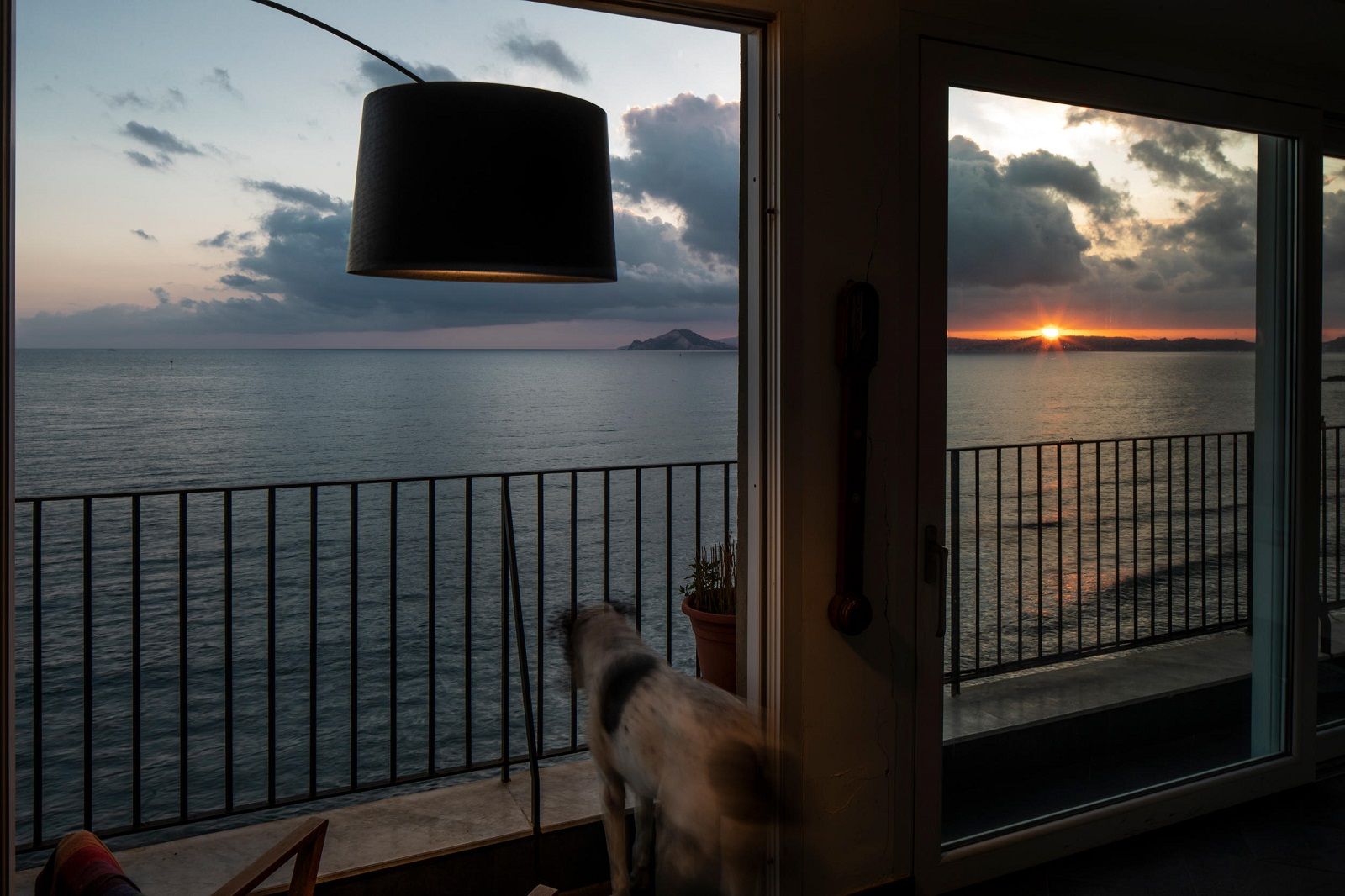 Twiggy Stehleuchte von Foscarini mit Blick auf das Meer bei Sonnenuntergang, modernes Wohnambiente mit Designleuchte.