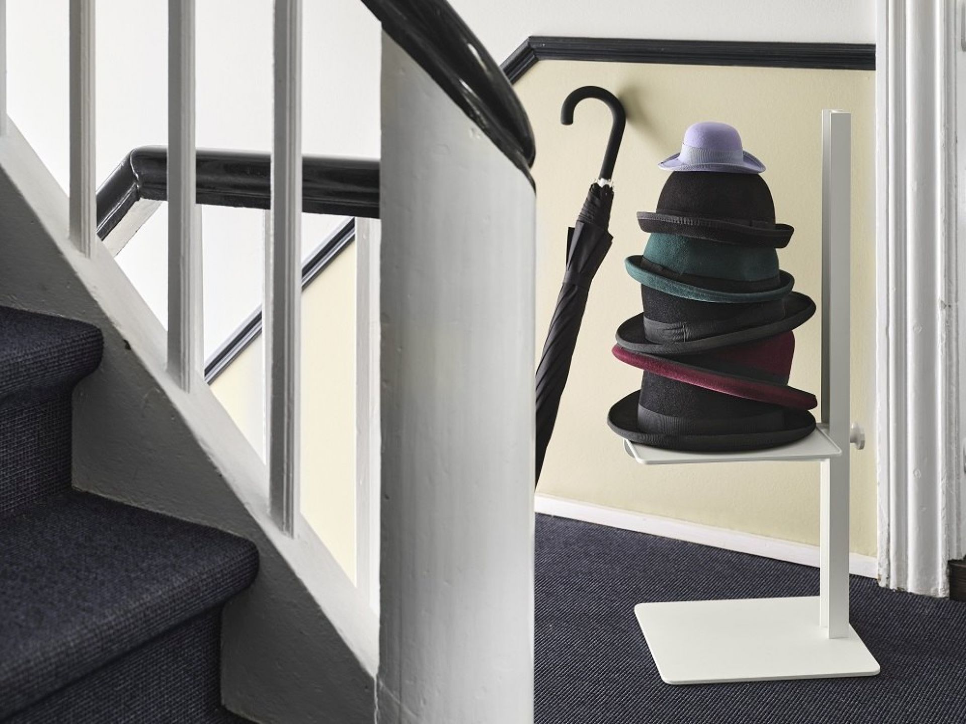 Museum Sidetable Beistelltisch von String Furniture mit Hüten und Regenschirm im Flur.