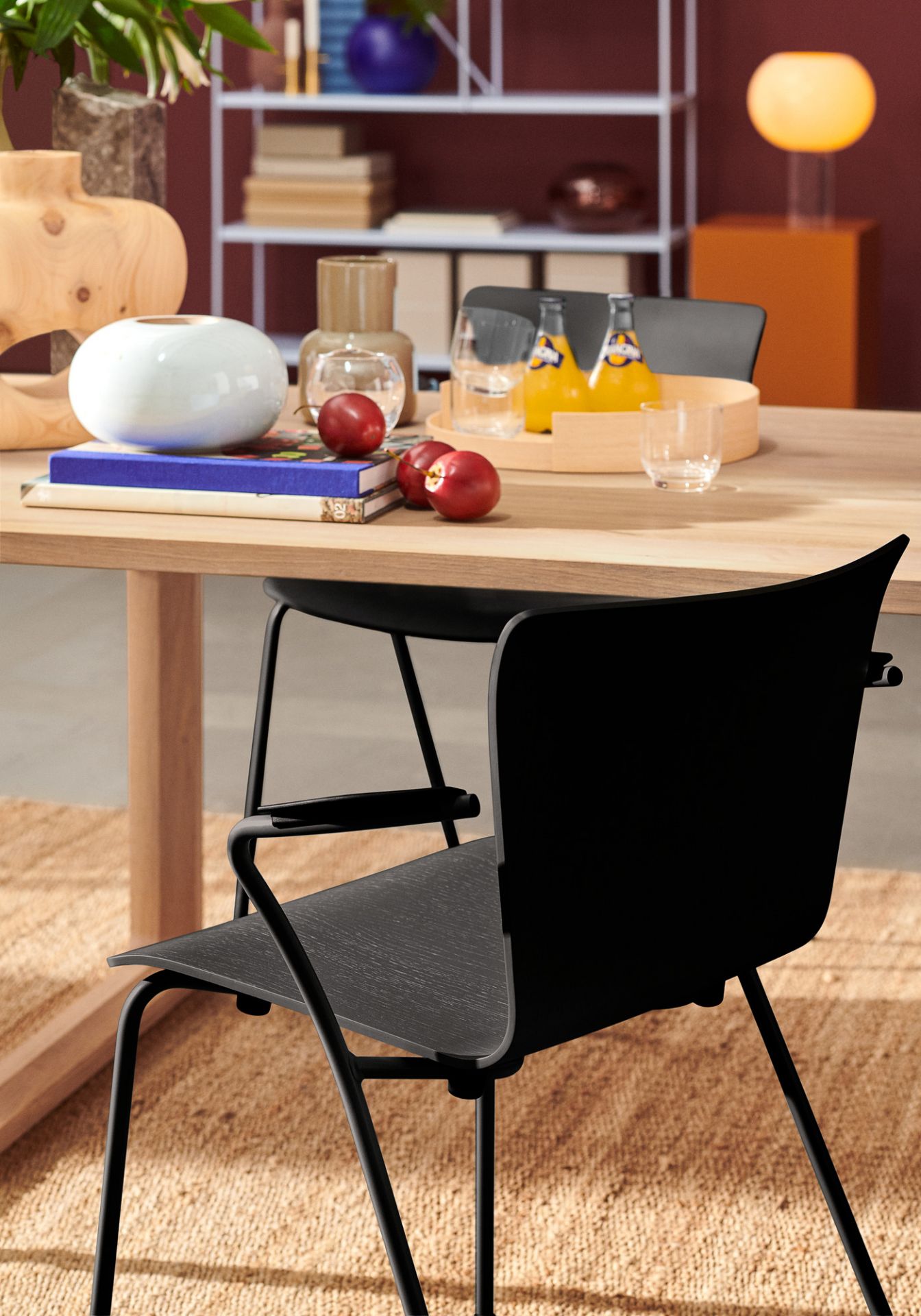 Schwarzer Vico Duo Stuhl von Fritz Hansen mit Armlehne vor einem Esstisch und Teppich.