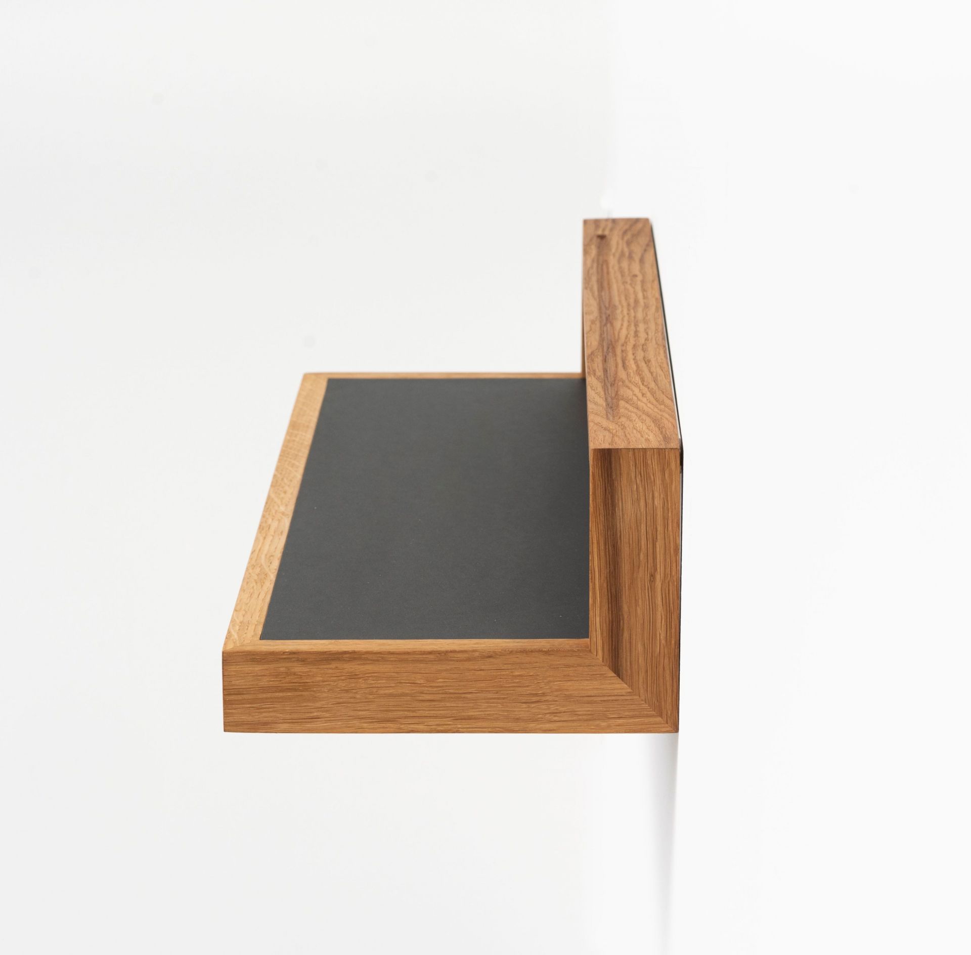 Anthrazitfarbenes Ablageboard buck2 aus Holz, seitliche Ansicht. Wandregal für Büro oder Wohnzimmer.