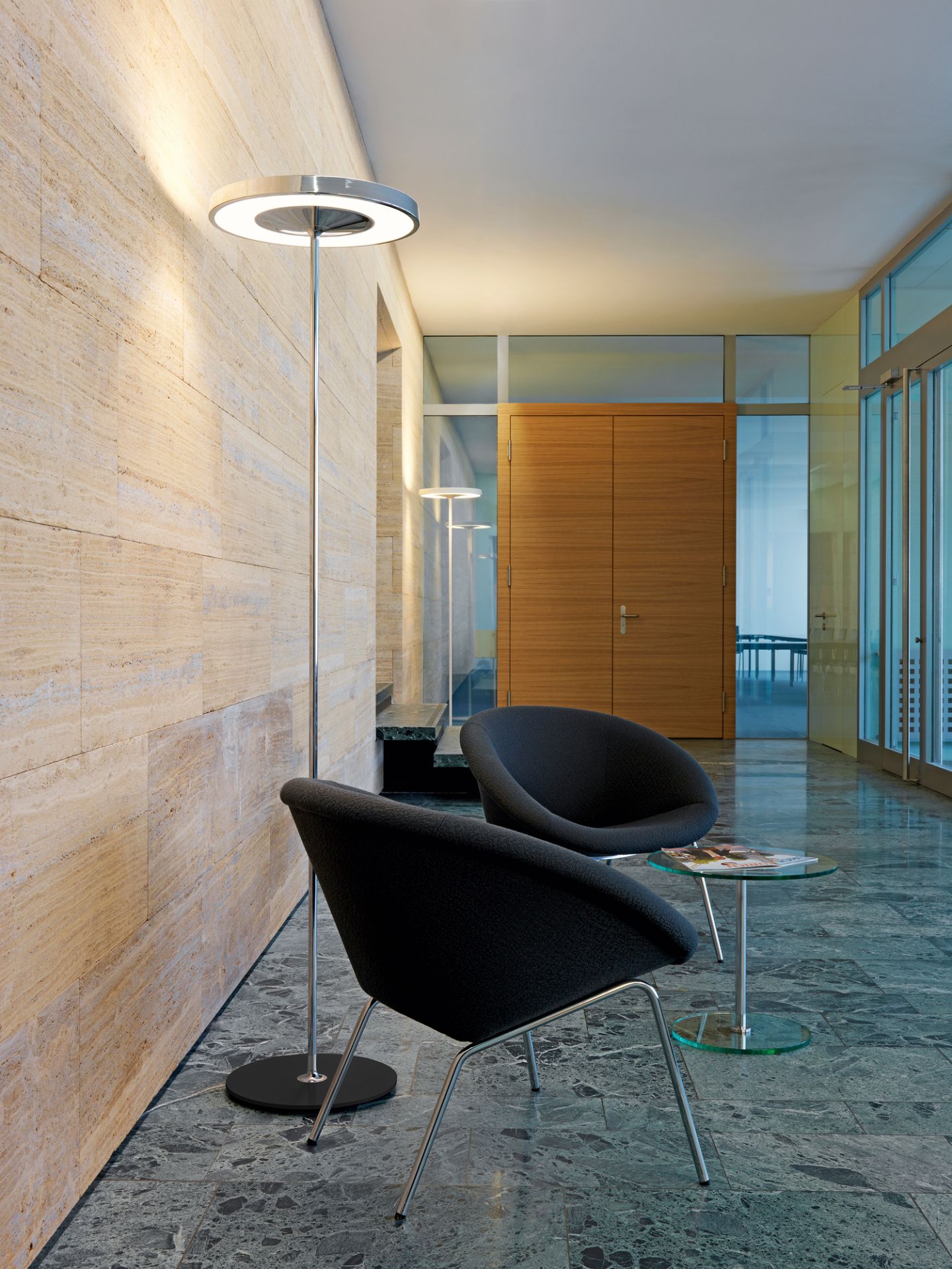 Disk Stehleuchte von Belux, moderne Bodenleuchte mit kreisförmigem Lampenschirm in einem Wartebereich.