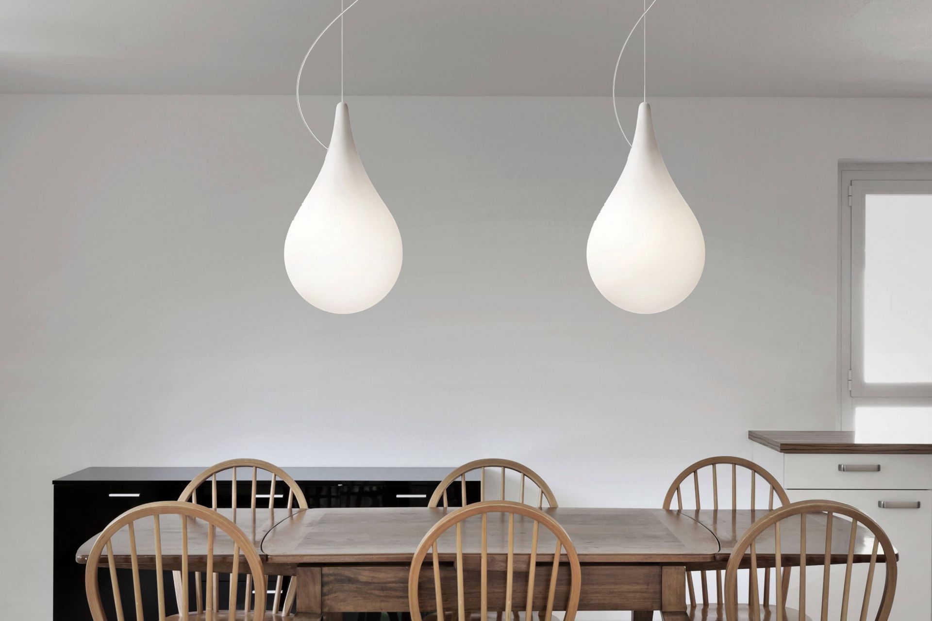 Zwei Liquid Light Drop Pendelleuchten über Esstisch, moderne Innenbeleuchtung, Tropfenform, weiß.