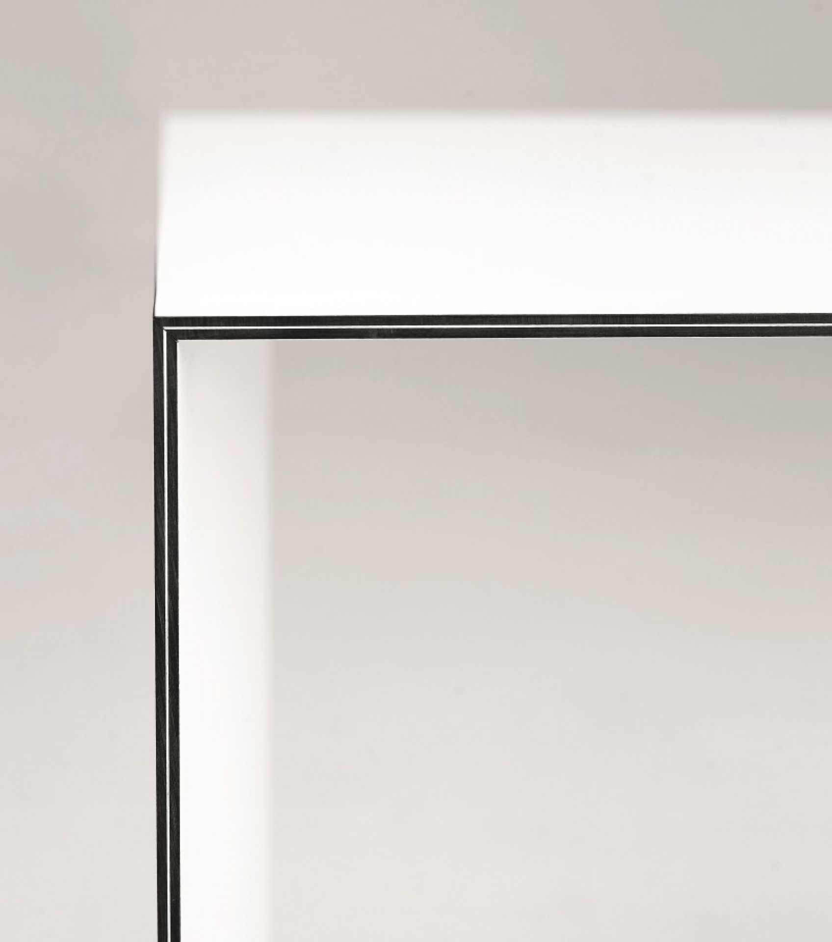 Detailaufnahme vom Karl Andersson & Soener Thinner Tisch: Weiße Tischplatte mit filigranem, schwarzem Metallgestell.