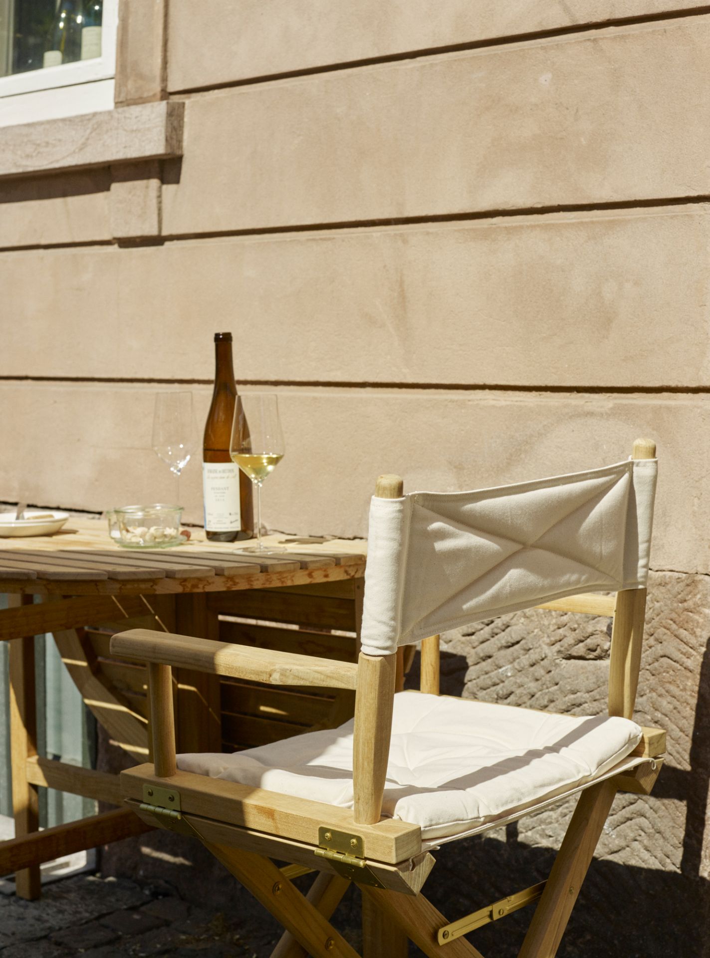 Skagerak Director's Chair Stuhl aus Teakholz mit weißem Stoffbezug für Indoor und Outdoor.