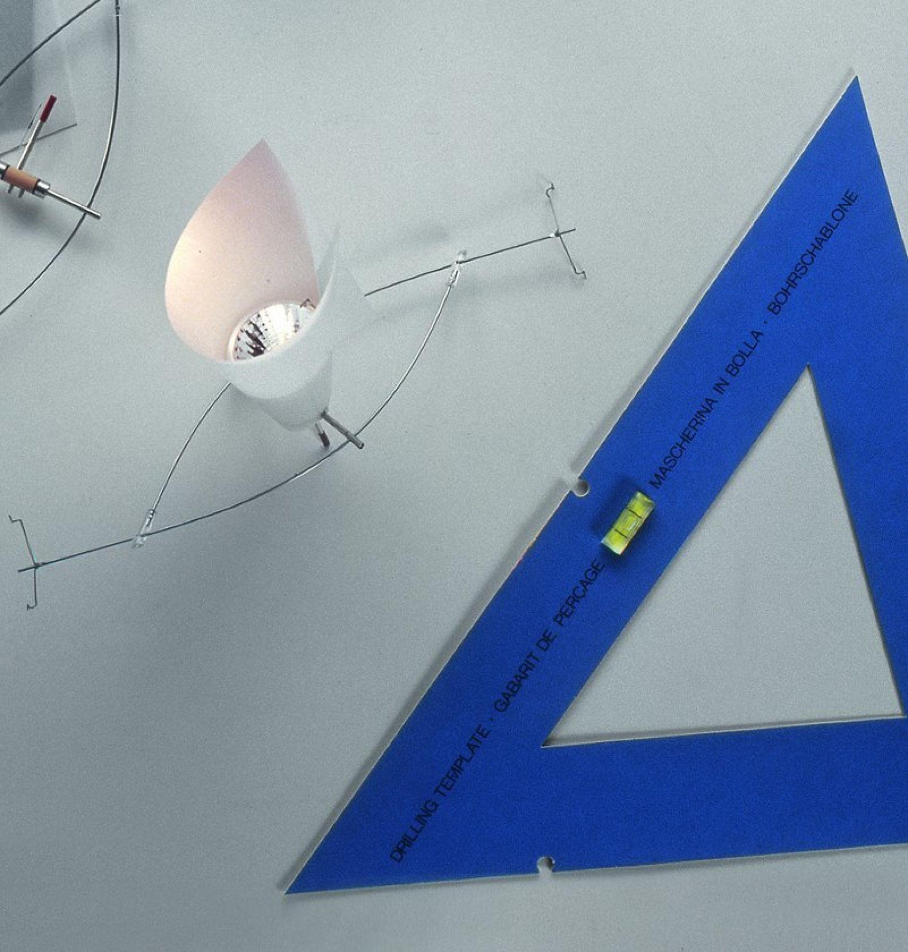 BAKARÚ Lichtelement von Ingo Maurer neben einer blauen Bohrschablone. Design Lampe für Wohnraum.