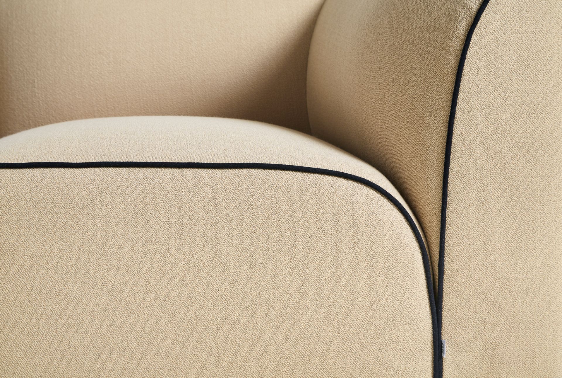 Detailaufnahme des Flora Sofas von Woud: Beige Polsterung mit schwarzer Paspelierung. Modulares Sofa für Wohnzimmer.