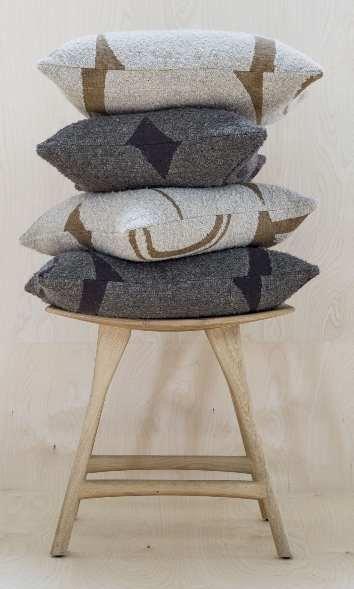 Osso Stuhl aus Eiche von Ethnicraft mit Kissenstapel in Grau und Beige.