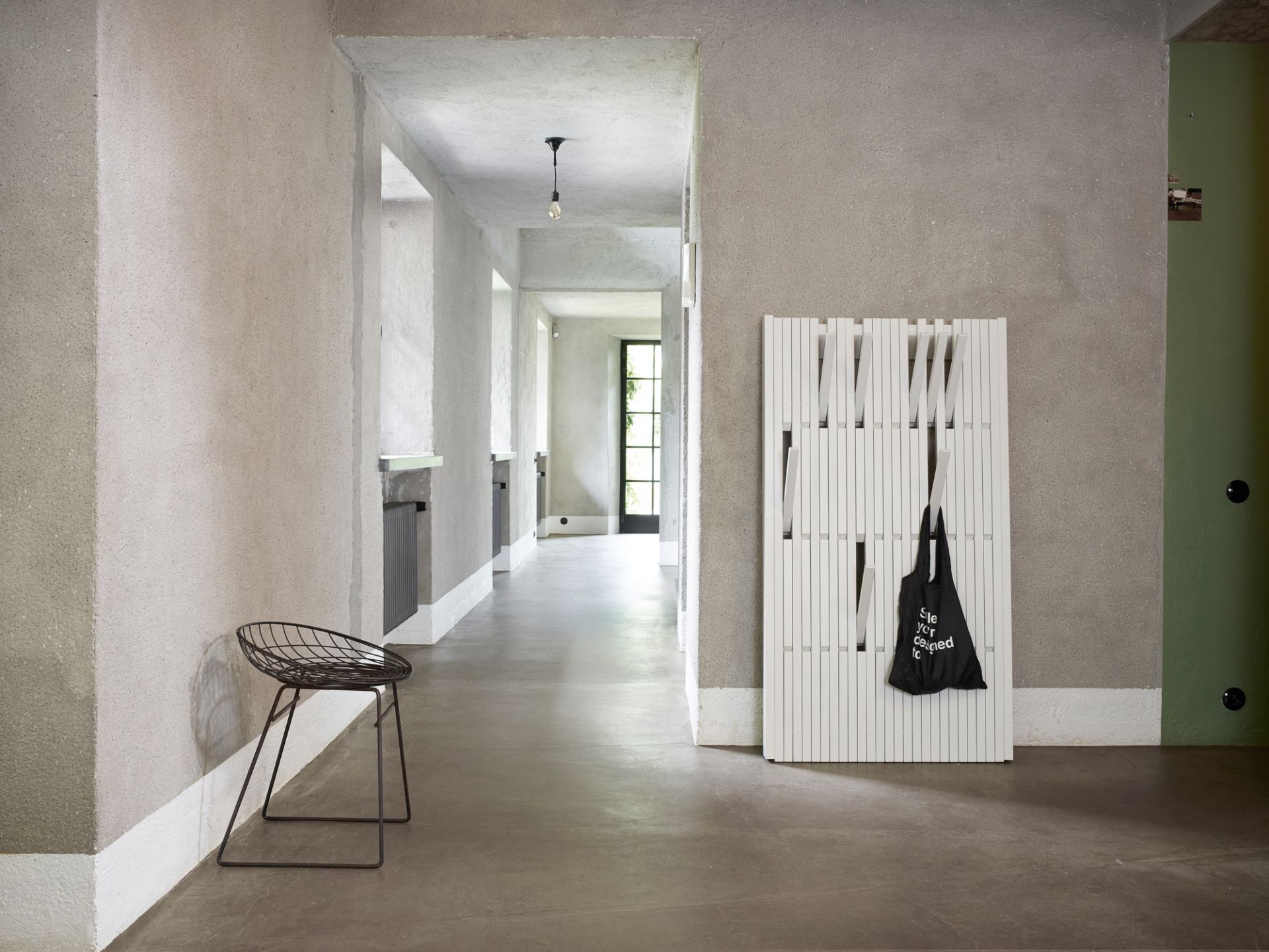 Weiße Piano Wandgarderobe von PER/USE mit schwarzer Stofftasche in modernem Flur. Design Garderobe.