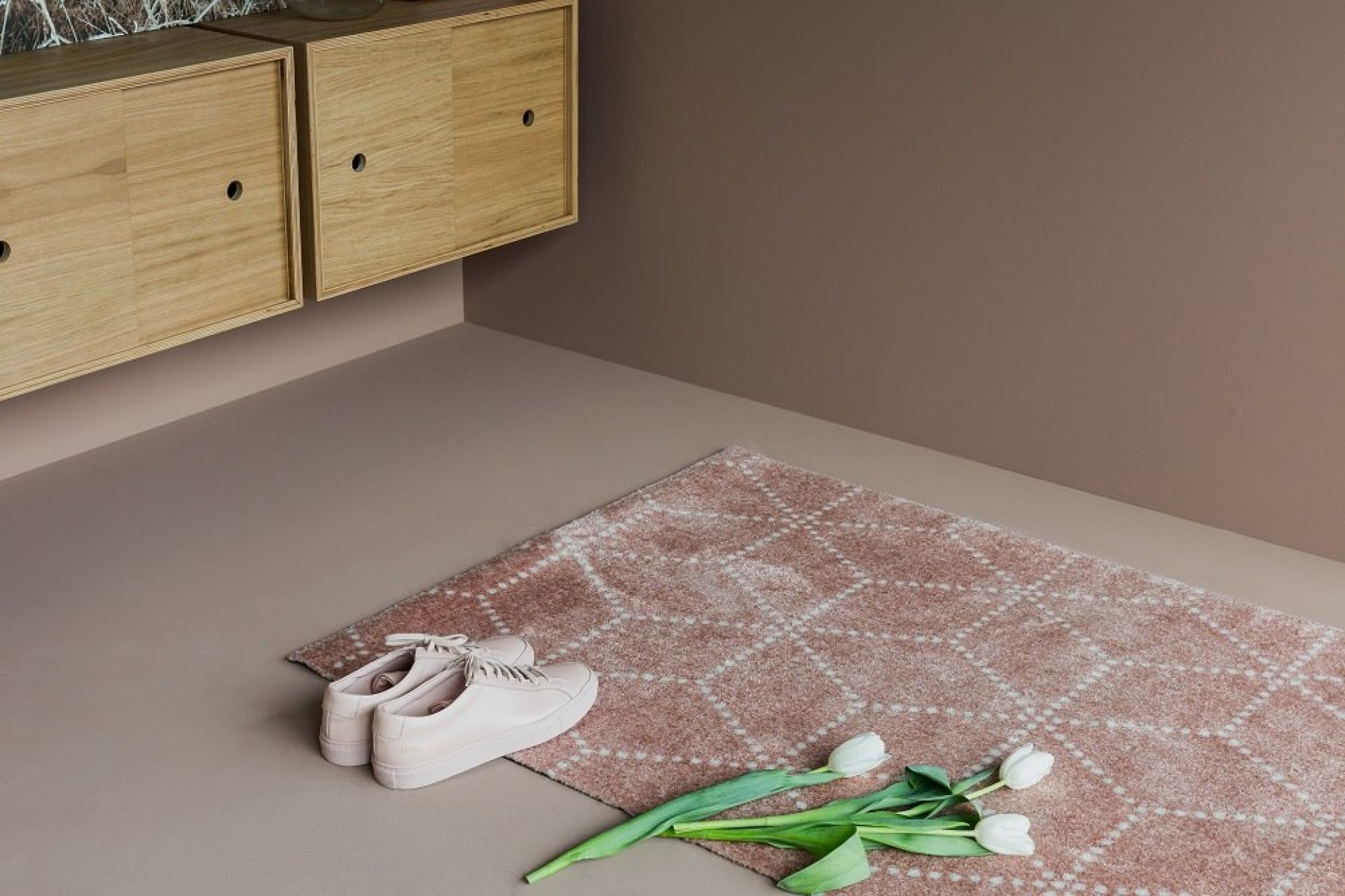 Hagl Heymat Fußmatte in Schwarz, 60x85 cm, mit Schuhen und Tulpen auf dem Boden.