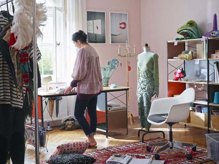 Weißer Eames Plastic Arm Chair PACC mit Sitzpolster von Vitra in einem kreativen Arbeitszimmer.
