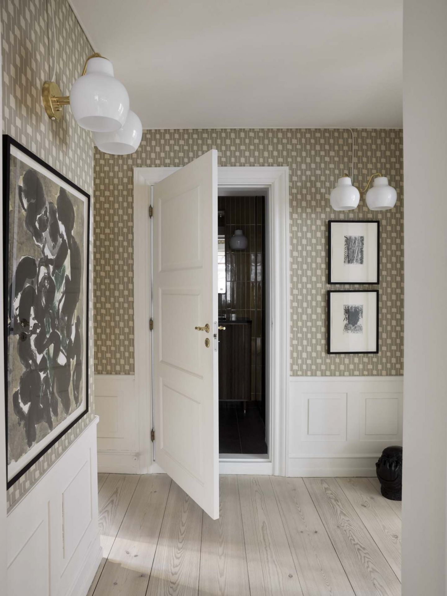 Flur mit VL Ring Crown Wandleuchten von Louis Poulsen, weißen Wänden und Holzboden.