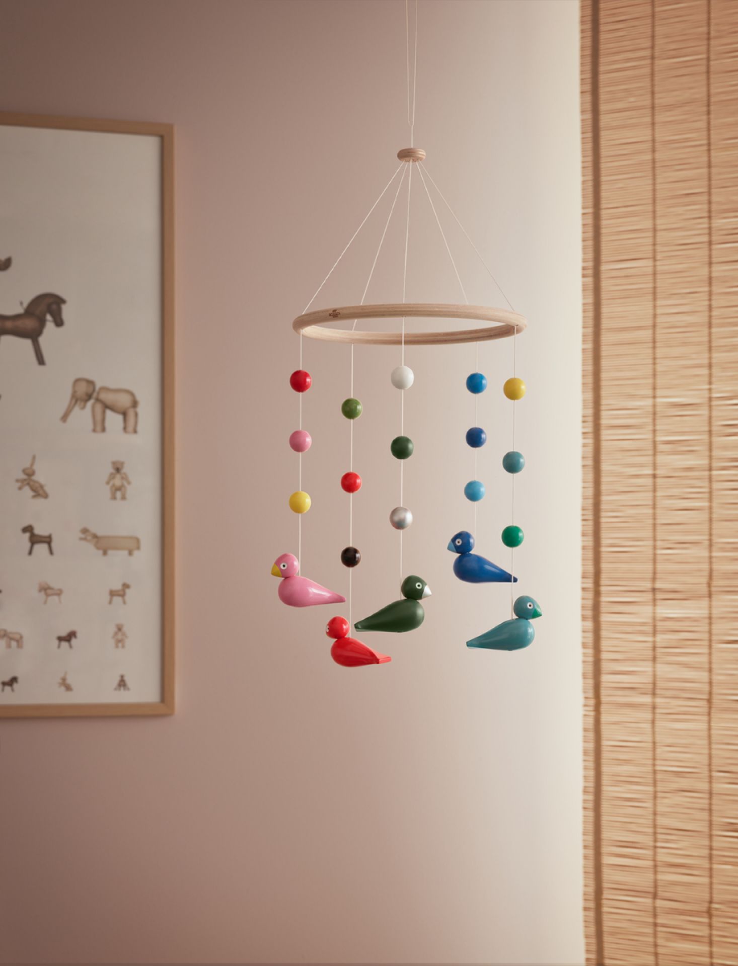 Uro Mobile von Kay Bojesen mit bunten Holzvögeln und Kugeln, hängend im Kinderzimmer.