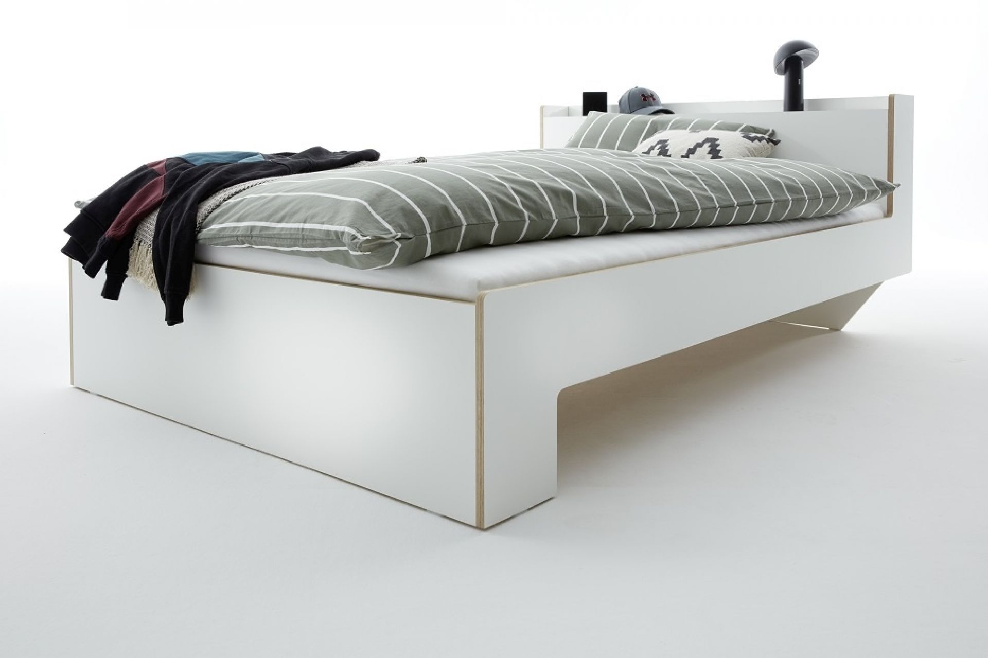 Nook Bett von Müller Möbelwerkstätten, Einzelbett in Weiß mit Bettwäsche und Nachttisch-Ablage.