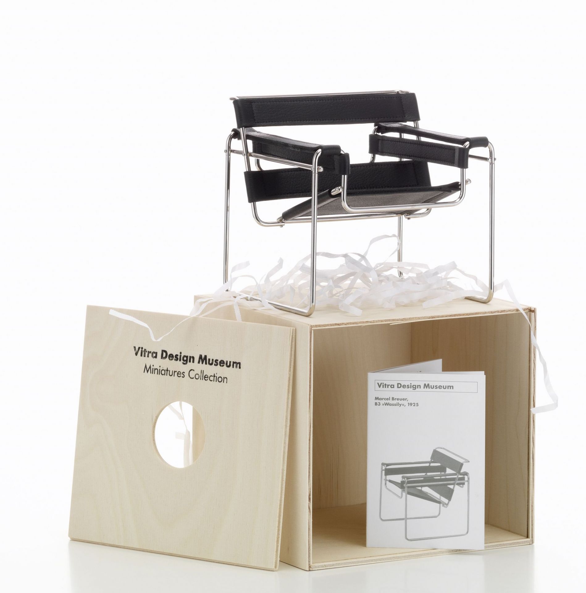 Miniatur Vitra Wassily Stuhl B3 aus Stahlrohr und schwarzem Leder auf Holzkiste.