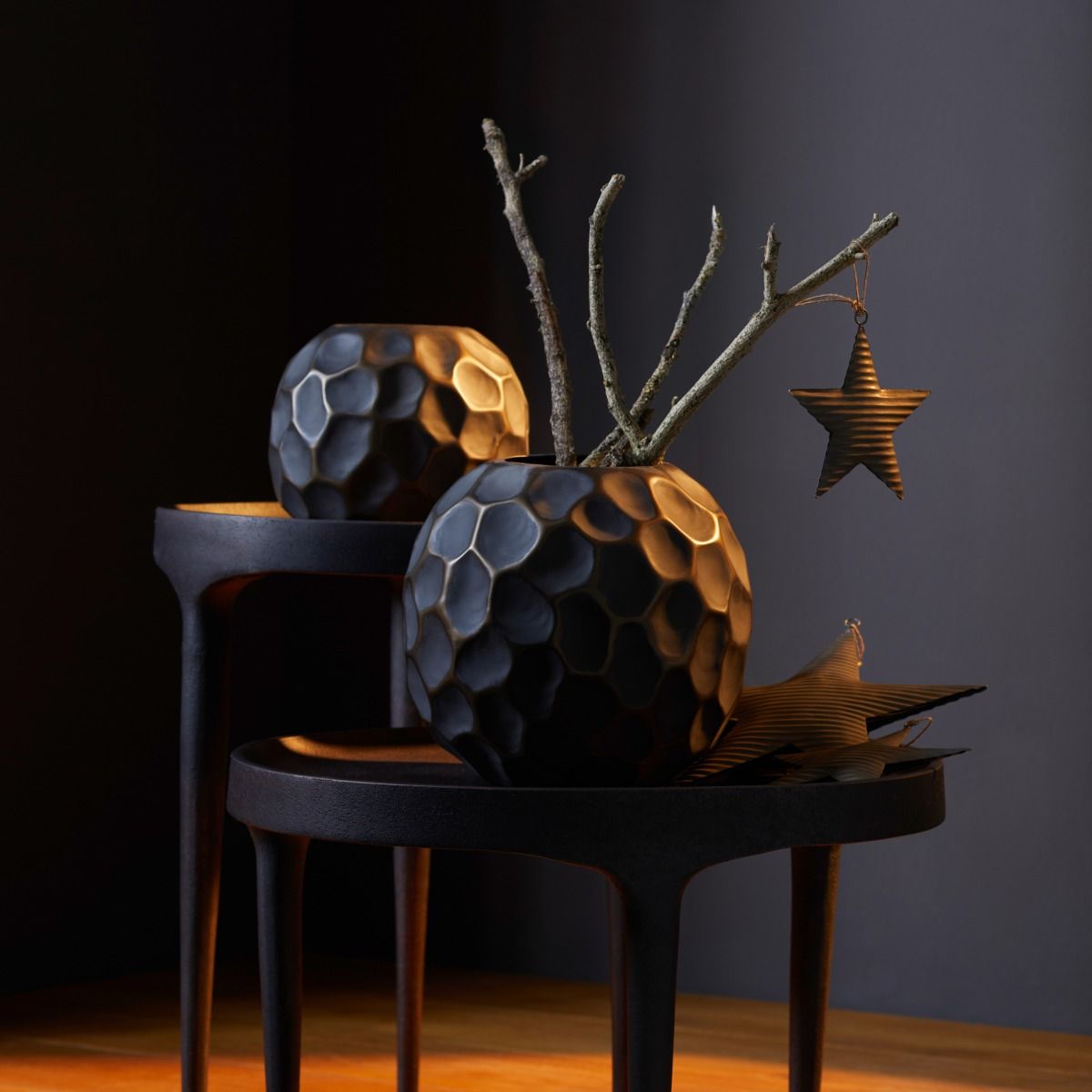 Dekorative Peru Vase von Philippi, schwarz mit Wabenmuster, auf einem kleinen Tisch mit Ästen und Sternen.