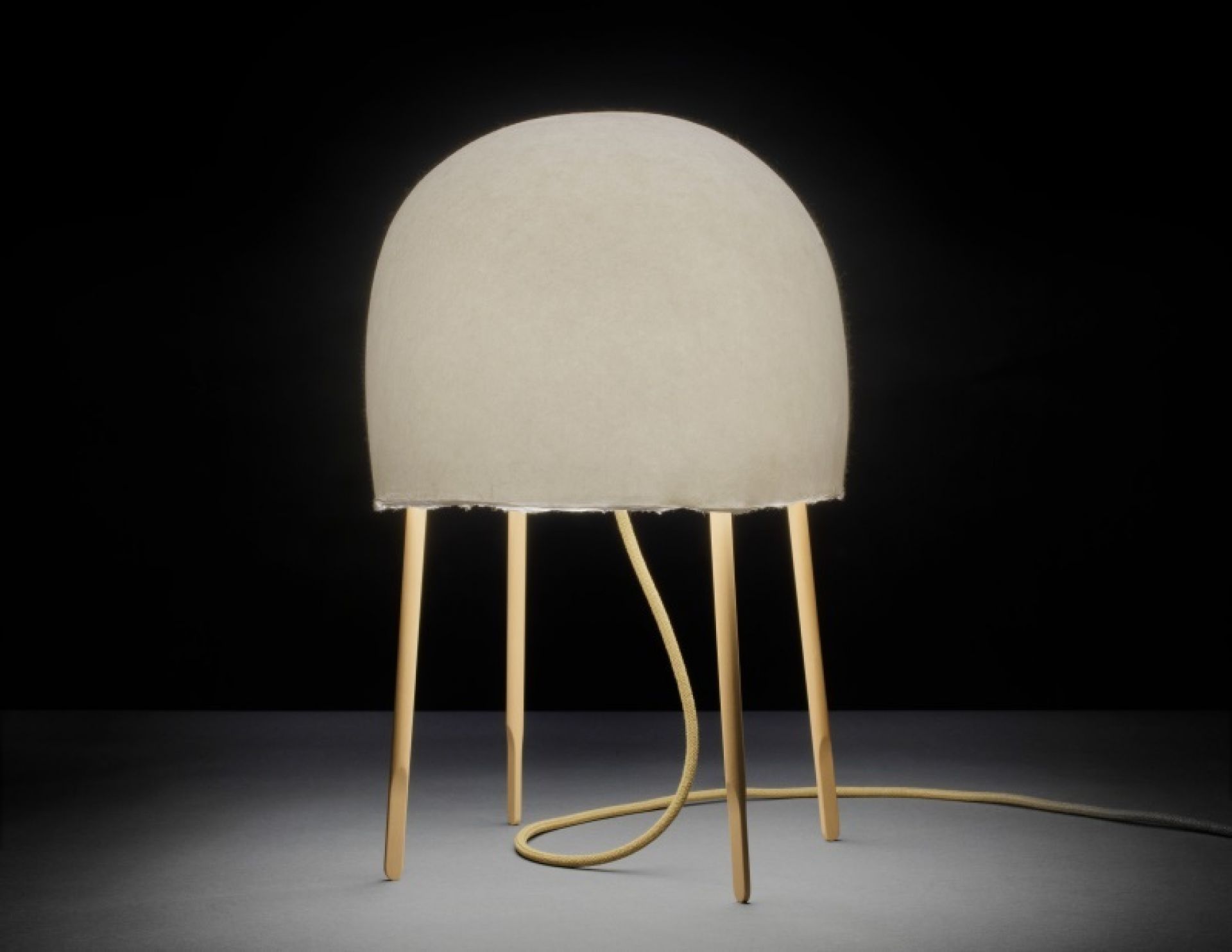 Nahaufnahme der Kurage Tischleuchte von Foscarini mit beigem Schirm und Holzbeinen.