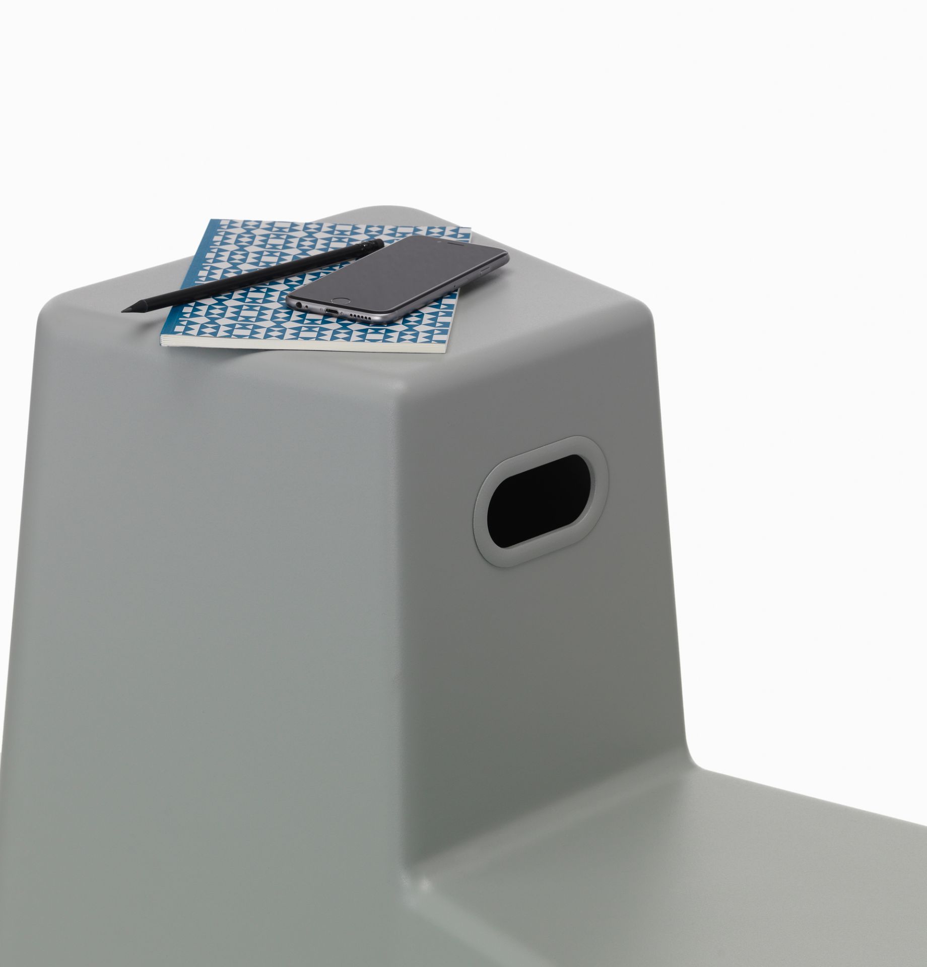 Grauer Stool Tool Stuhl von Vitra mit Notizblock, Stift und Smartphone. Modernes Möbeldesign.