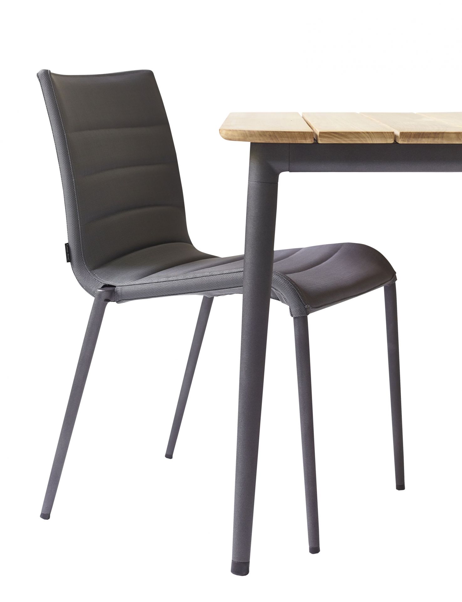 Cane-Line Core Outdoor Stuhl AirTouch in Grau neben einem Gartentisch mit Holzplatte.