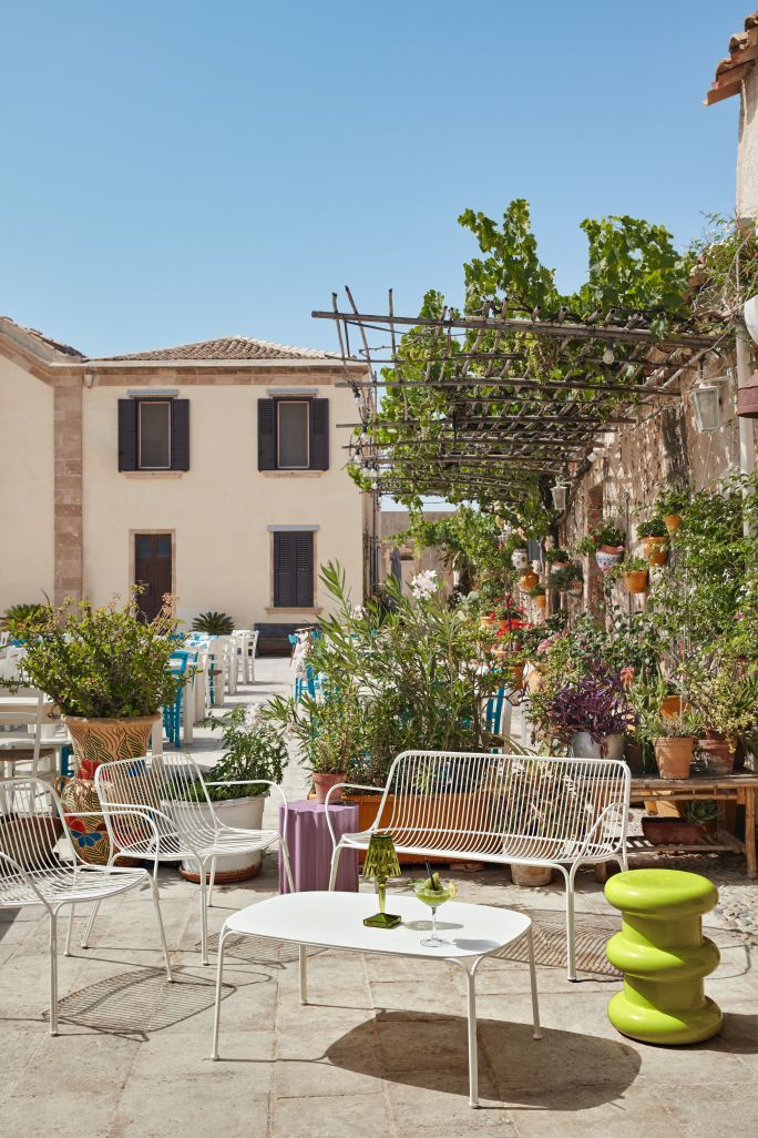 Hiray Kaffeetisch von Kartell im Außenbereich mit Stühlen und grünen Akzenten. Moderner Outdoor-Tisch.